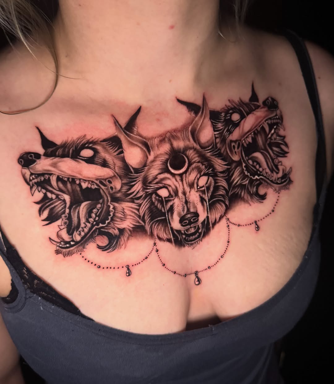 Wolf heads black and grey tattoo on the chest by Travis Sleeper