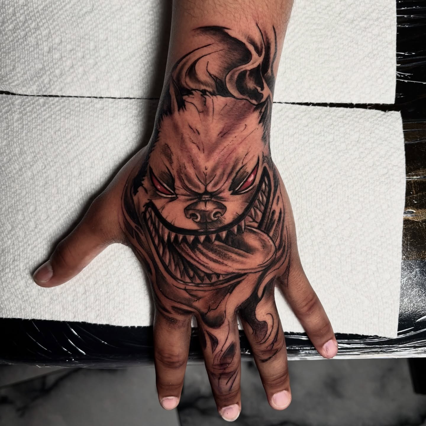 Demon face dark realism tattoo on the hand by Dave