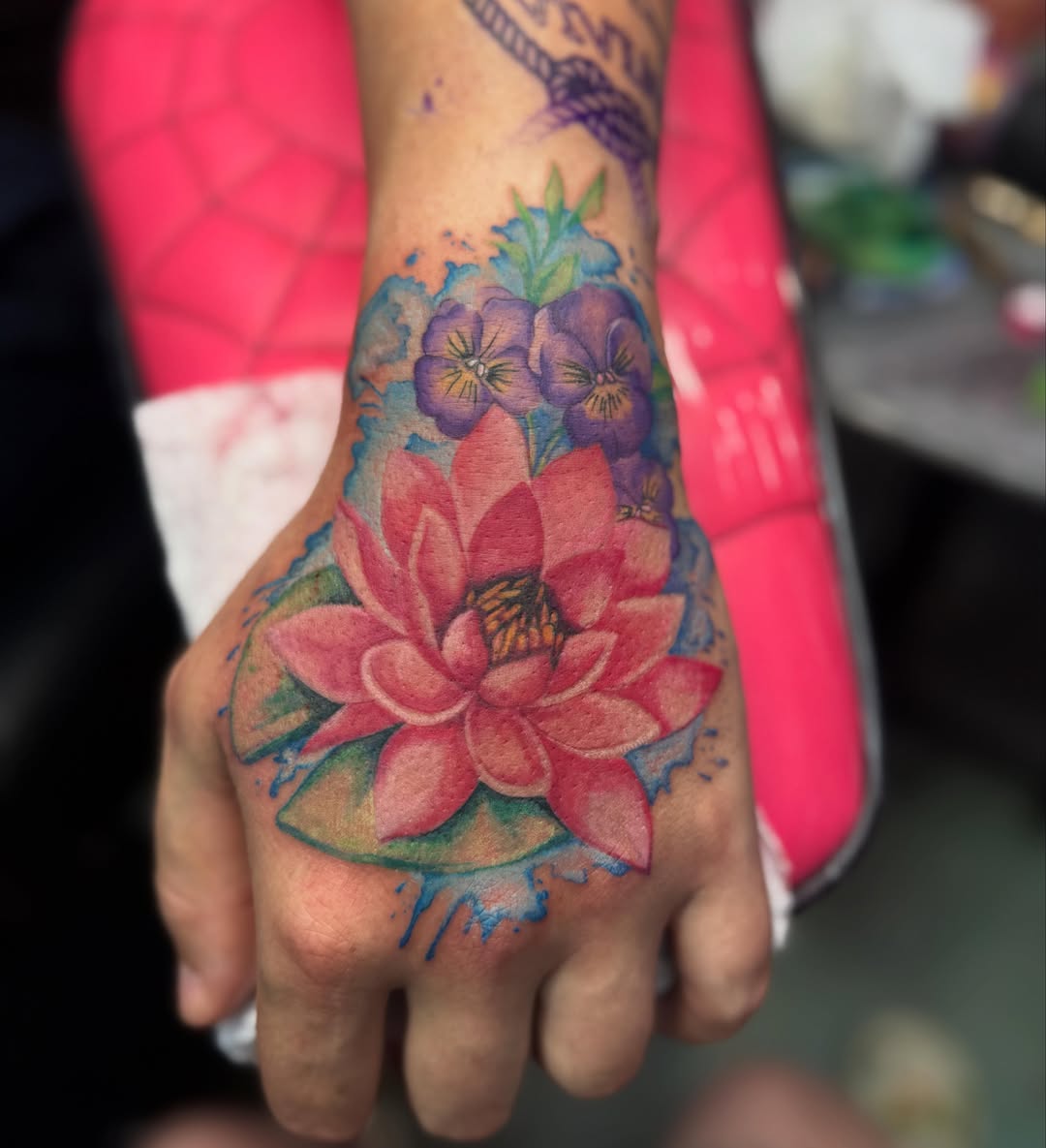 Lotus flower watercolor tattoo on the hand by Jada Reynolds