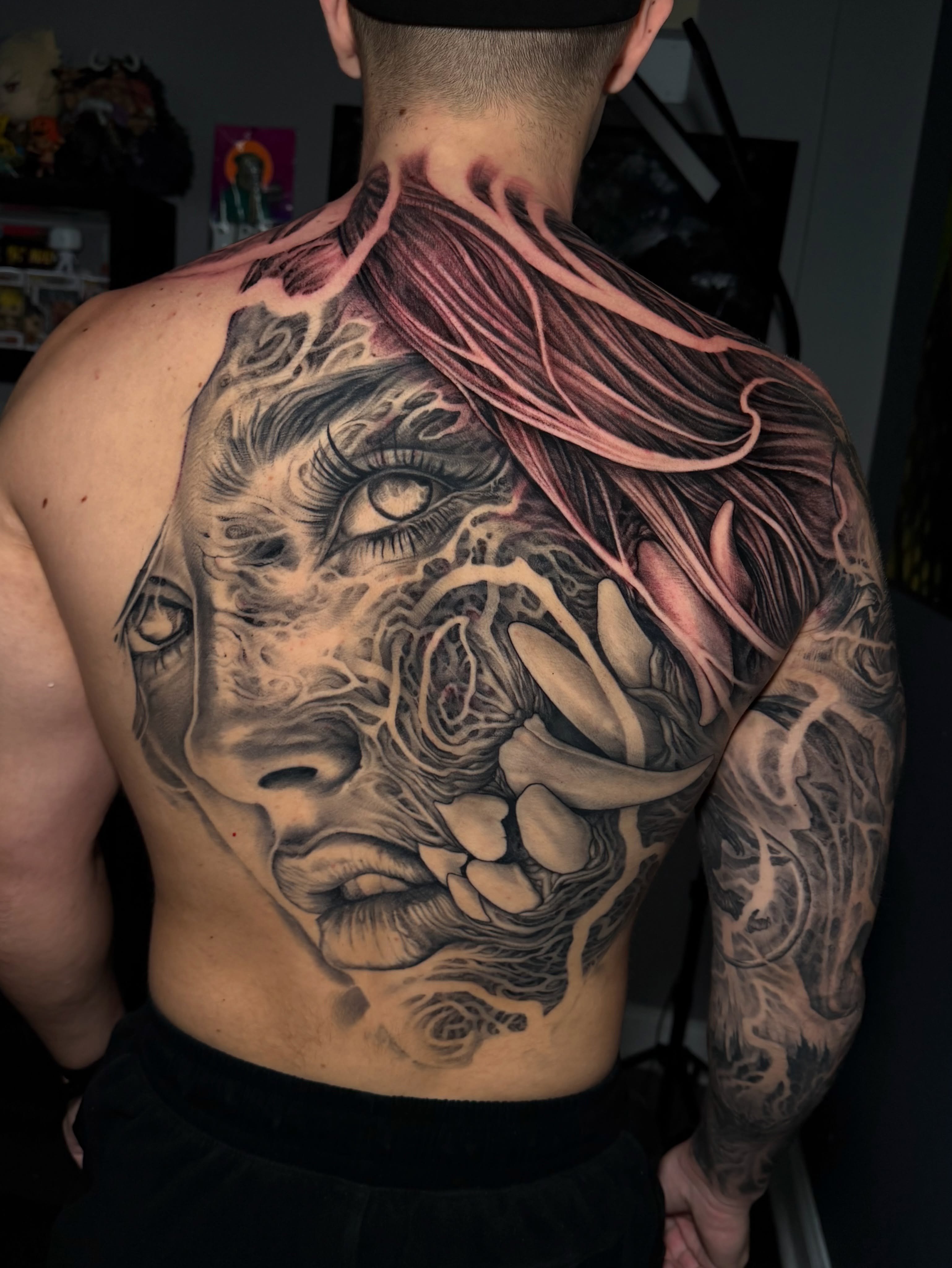 Surreal face with abstract elements dark art tattoo on the back by Nico Perez