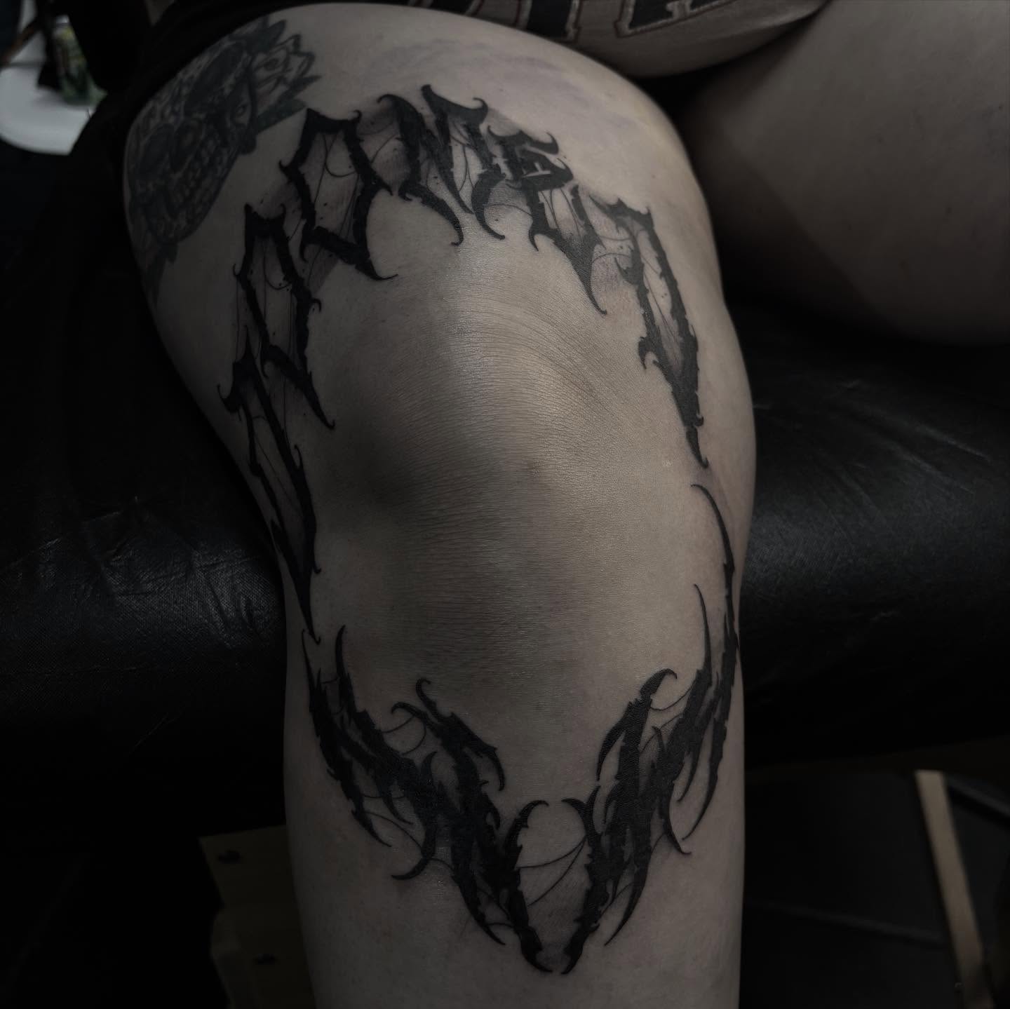 Gothic font black and grey tattoo on the thigh by suzie