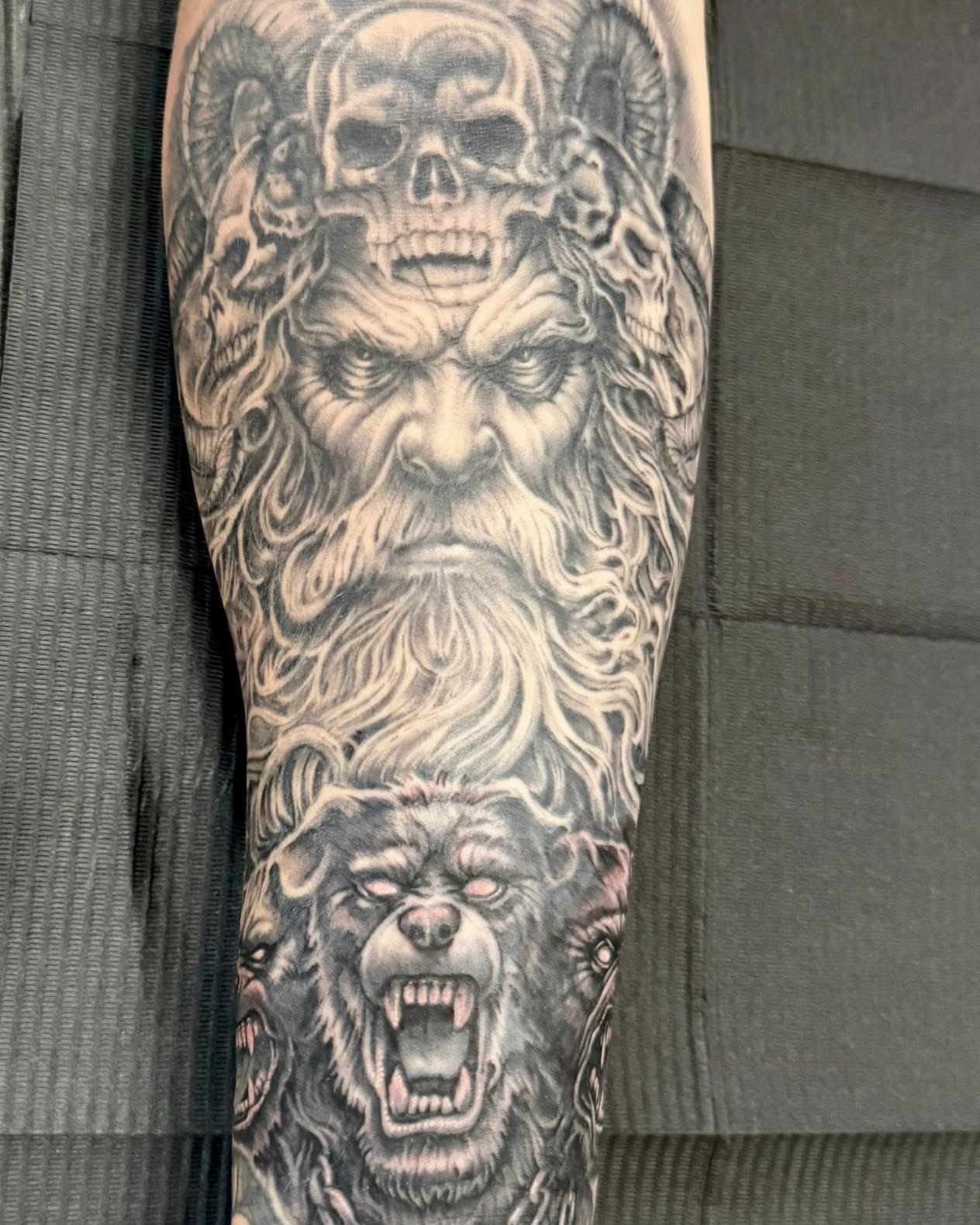 Bearded man with wolves realism tattoo on the forearm by Skott Kautman, Dubuque, Iowa