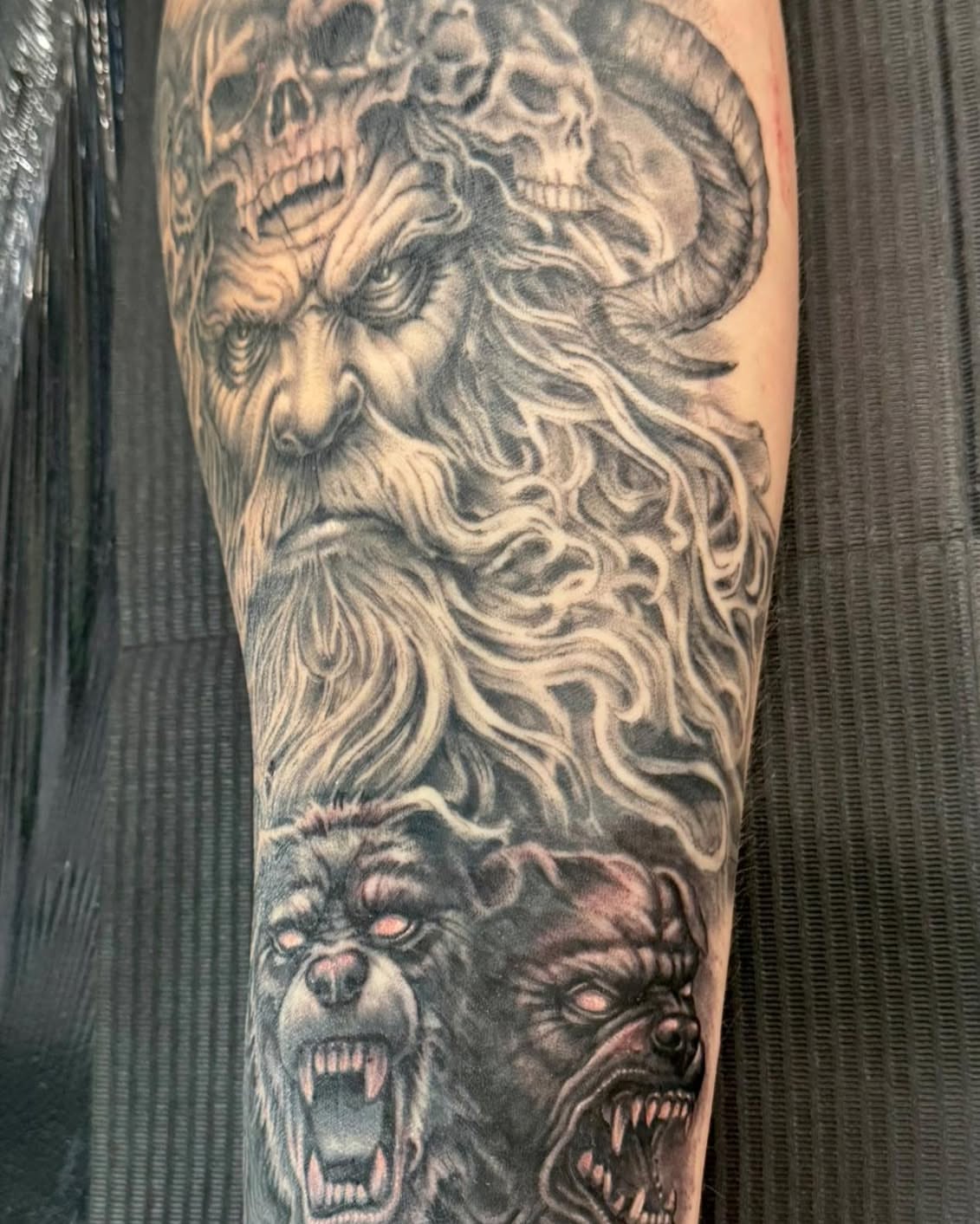 Bearded man with skulls realism tattoo on the forearm by Skott Kautman, Dubuque, Iowa