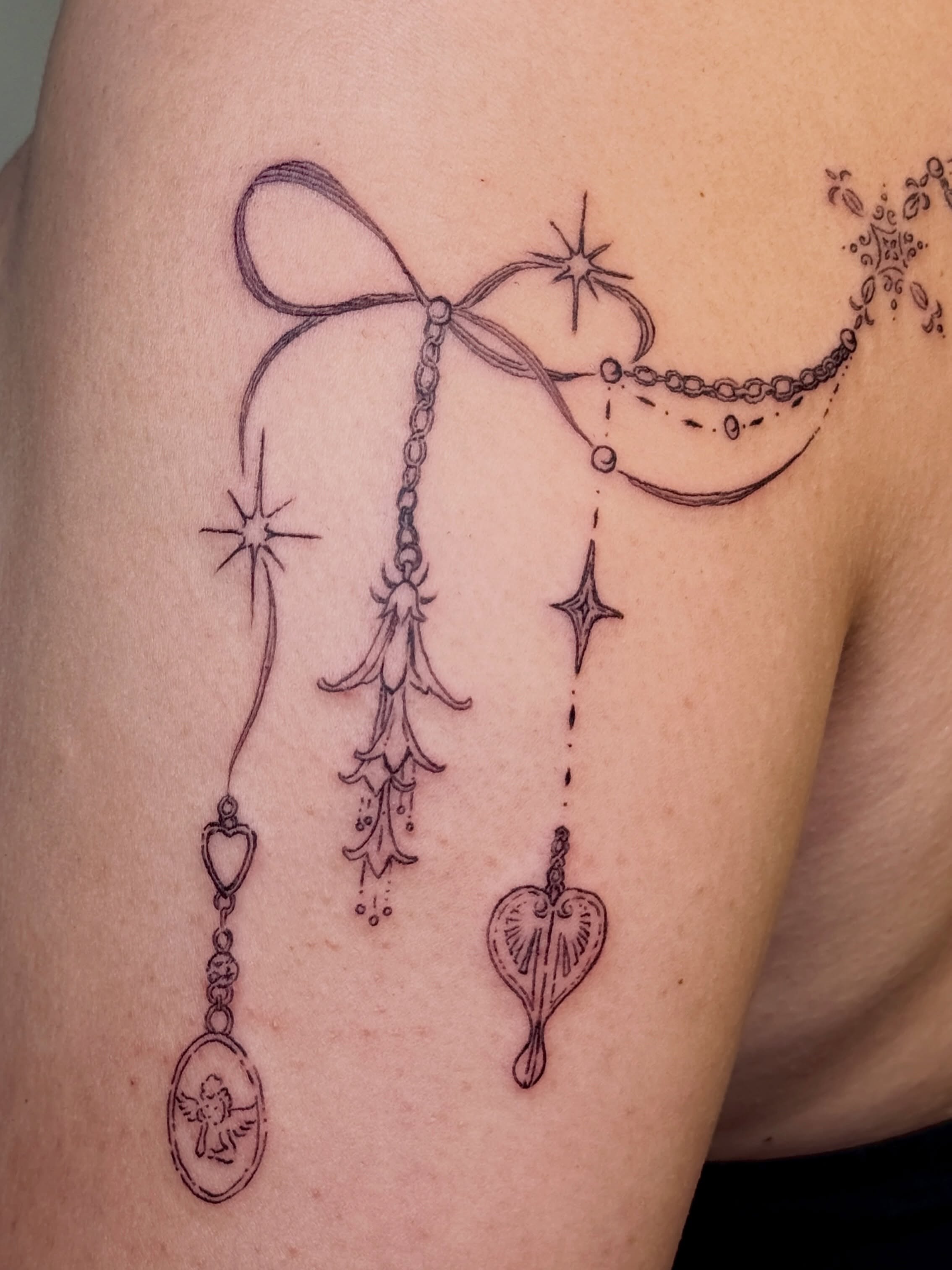 Bell and heart black and grey tattoo on the upper arm by Tater Tot Tats ꧁꧂ Myla
