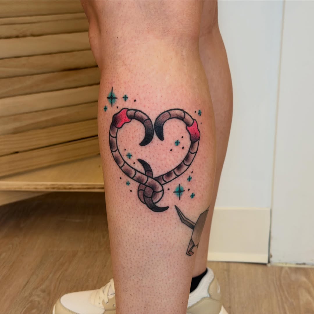 Heart-shaped snake dotwork tattoo on the calf by Gus Roach Graves