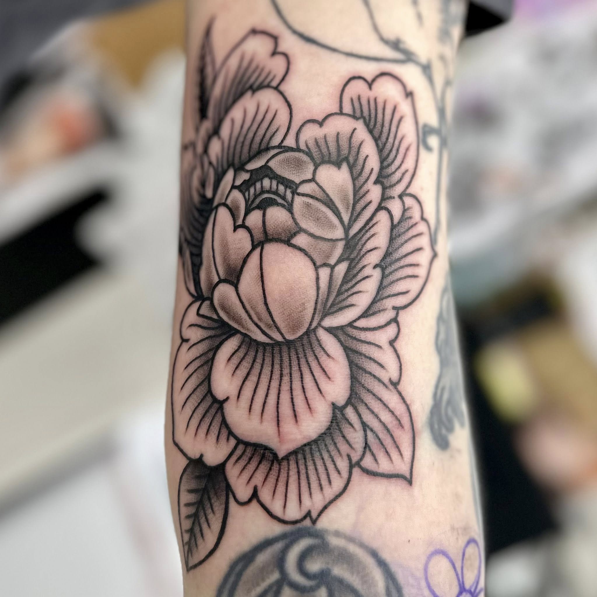 Peony flowers American traditional tattoo on the forearm by Jon Anderson
