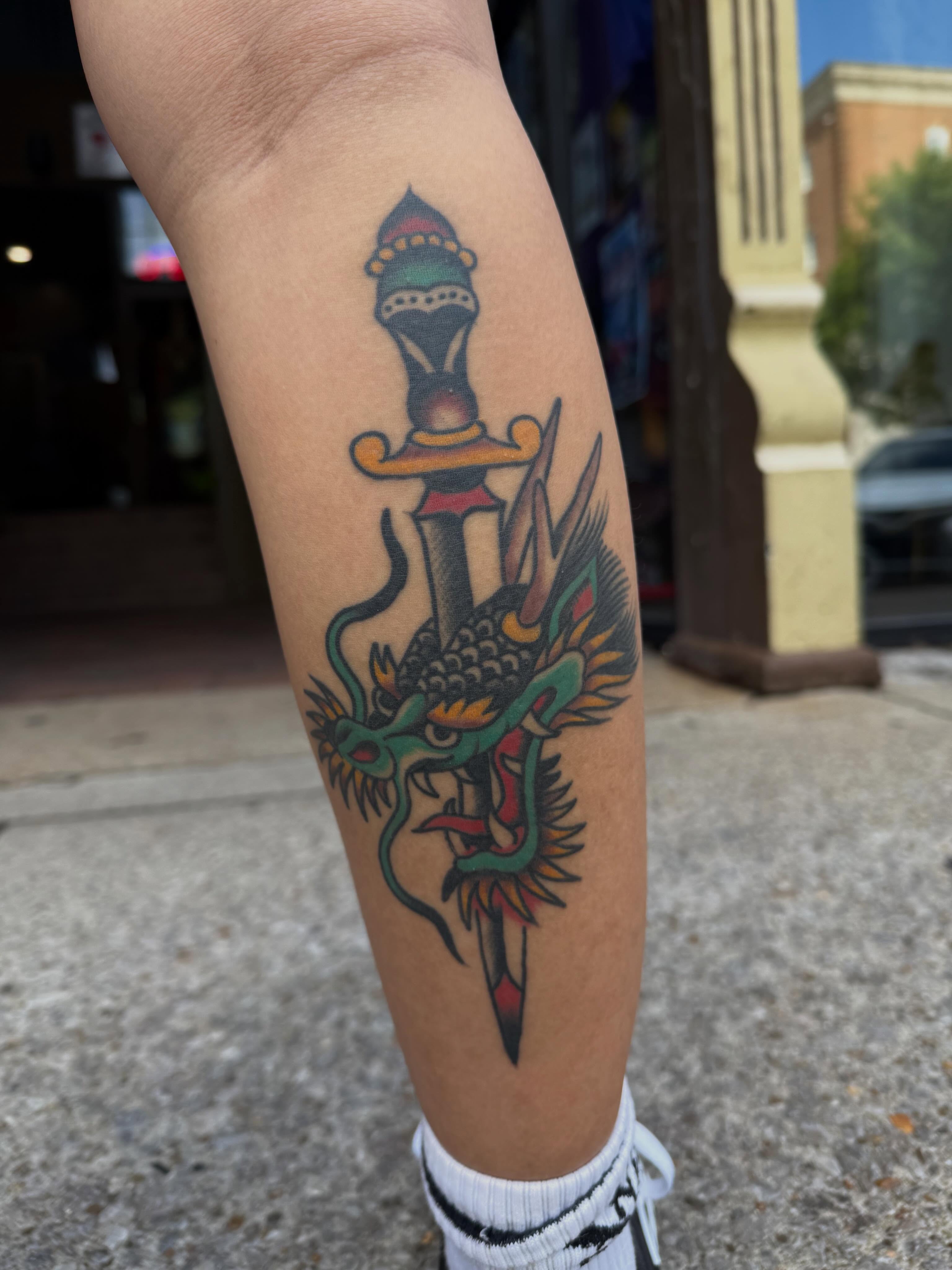 Dragon and sword American traditional tattoo on the forearm by Chris Dufresne