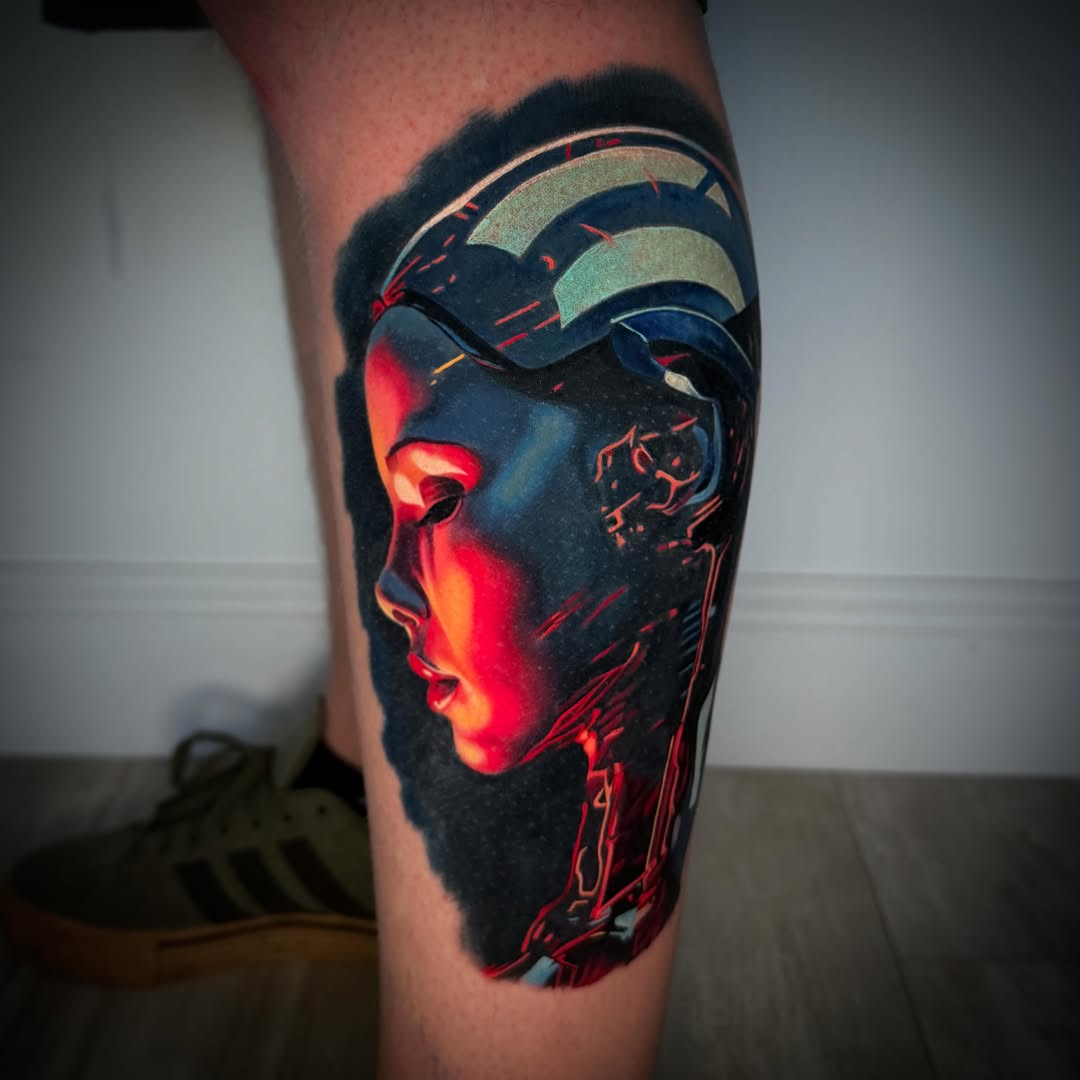 Cyborg face dark realism tattoo on the calf by TJ Schunemann
