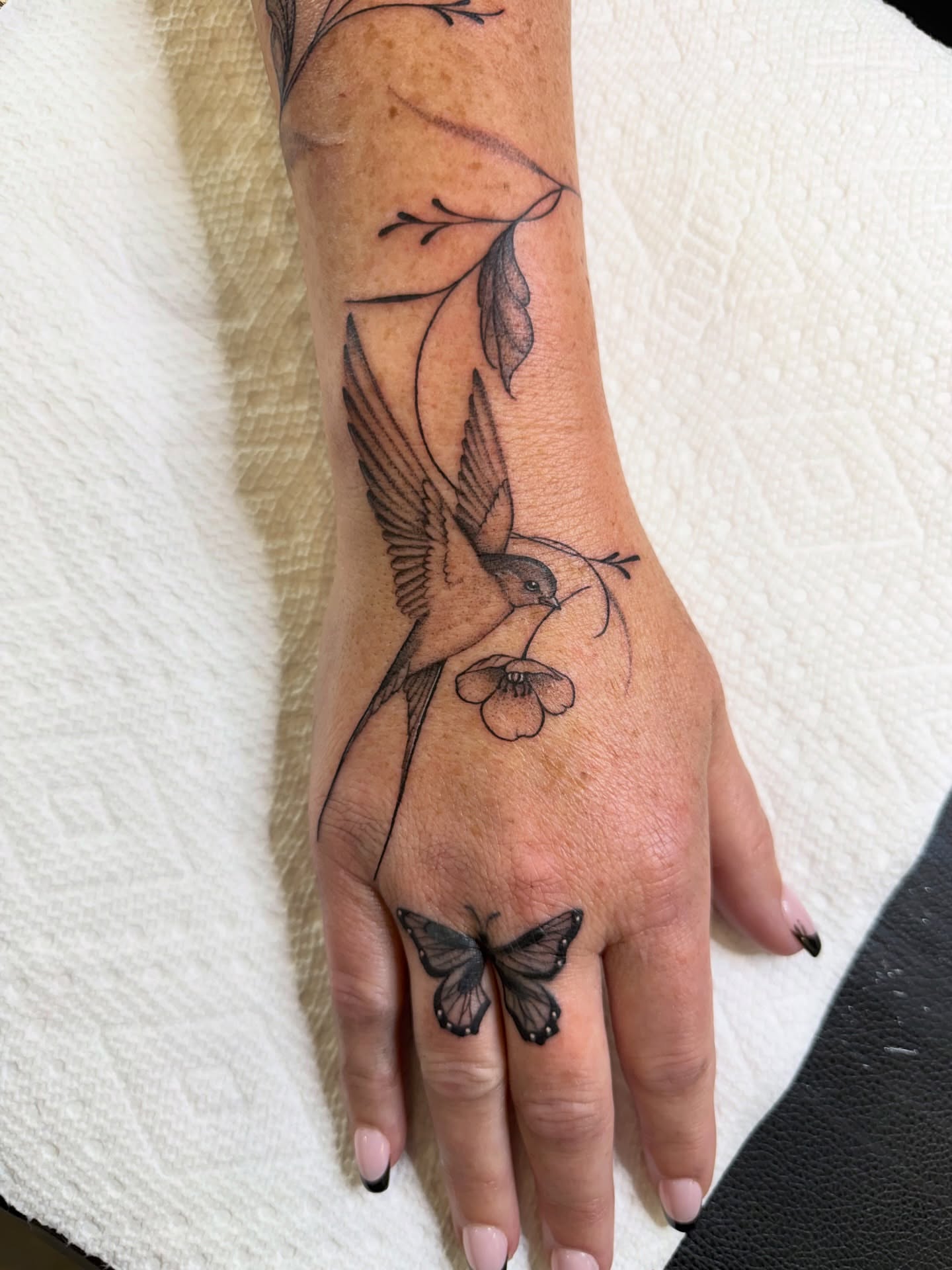 Bird and flower black and grey tattoo on the hand by WhoisLaineyTattoos