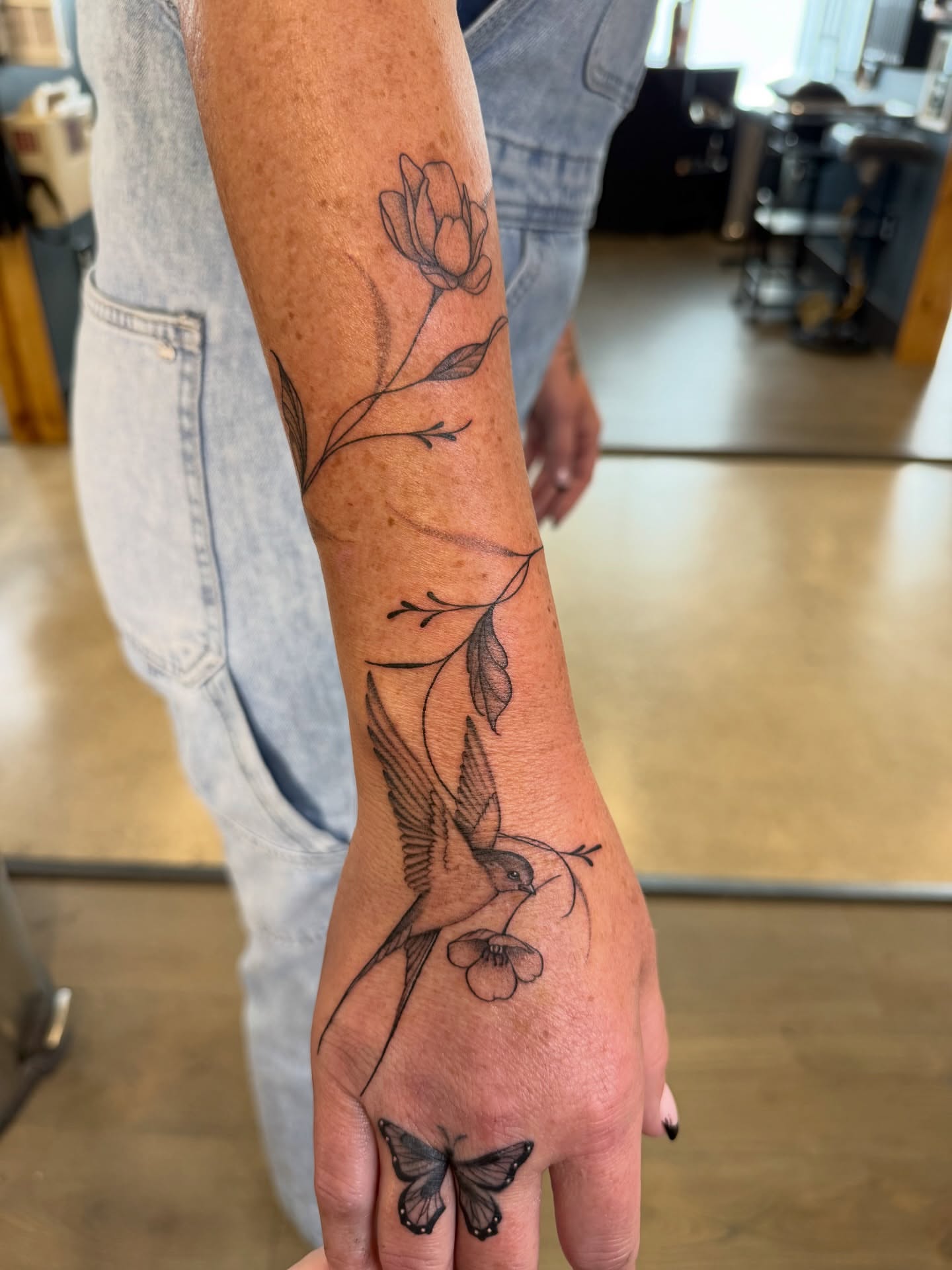 Bird and flower black and grey tattoo on the forearm by WhoisLaineyTattoos