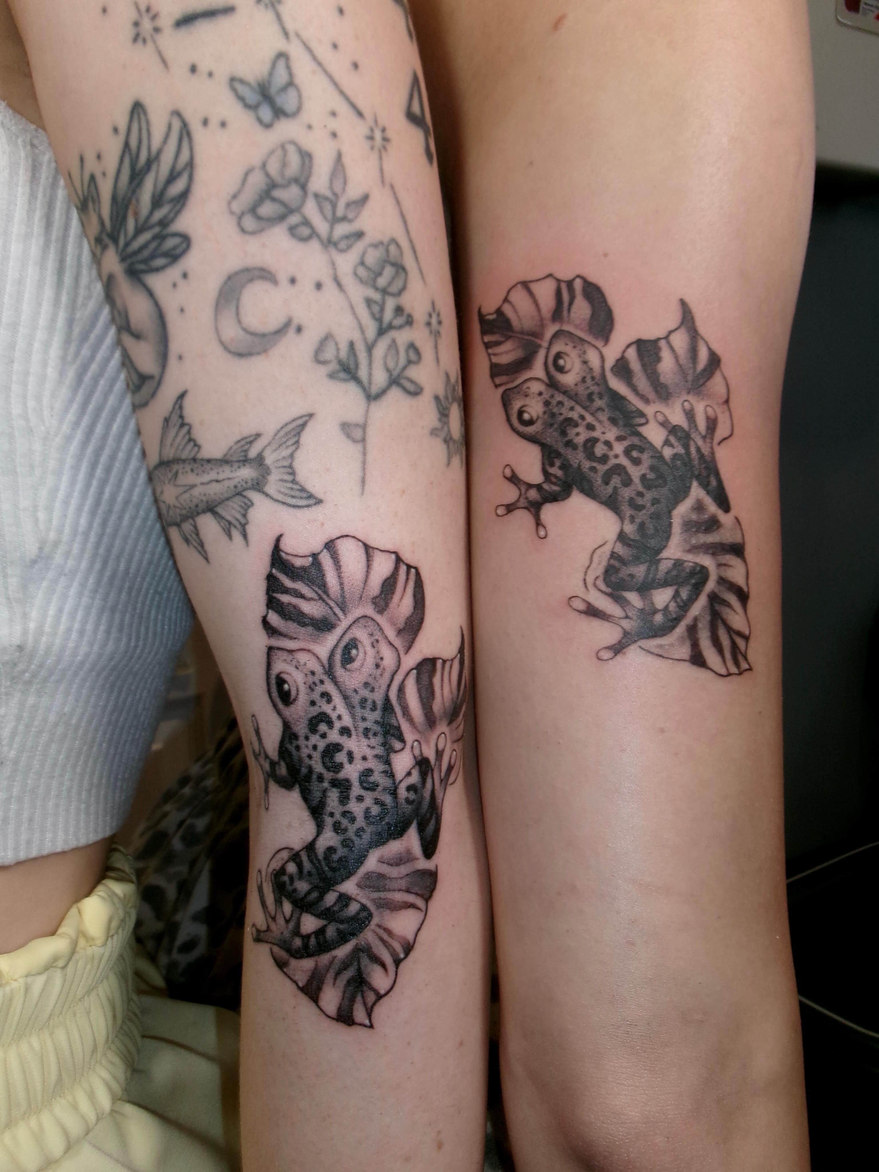 Frogs black and grey tattoo on the forearm by Ady Paige