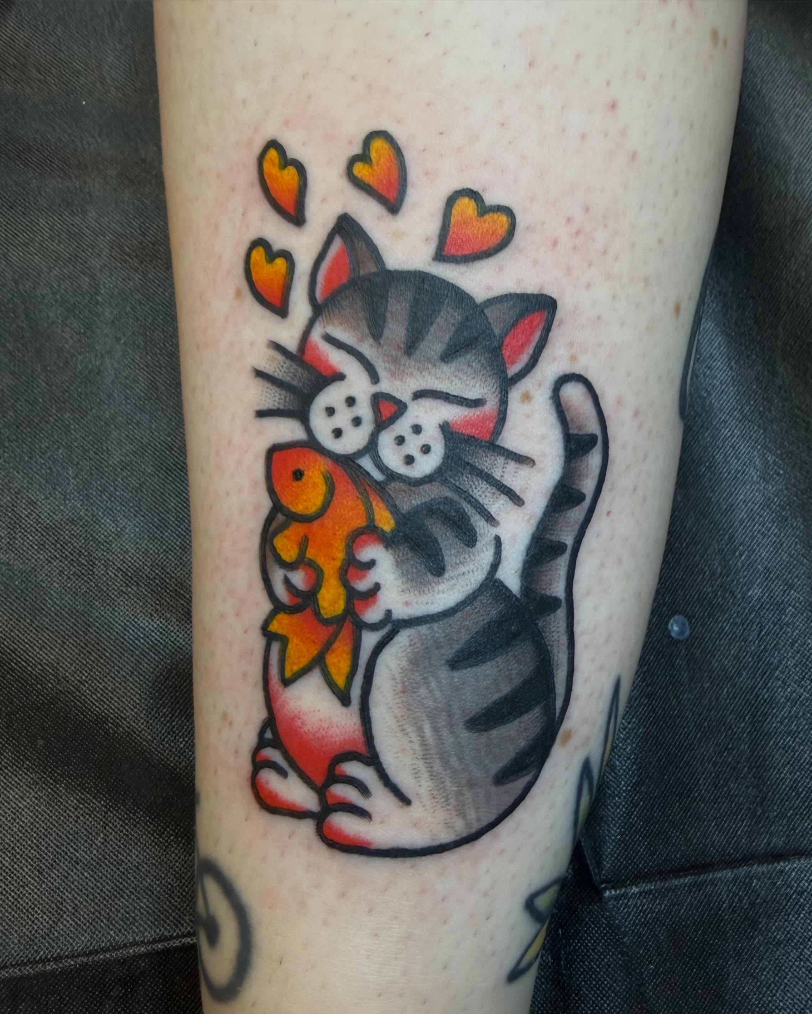 Cat hugging fish American traditional tattoo on the forearm by Hannah Jean