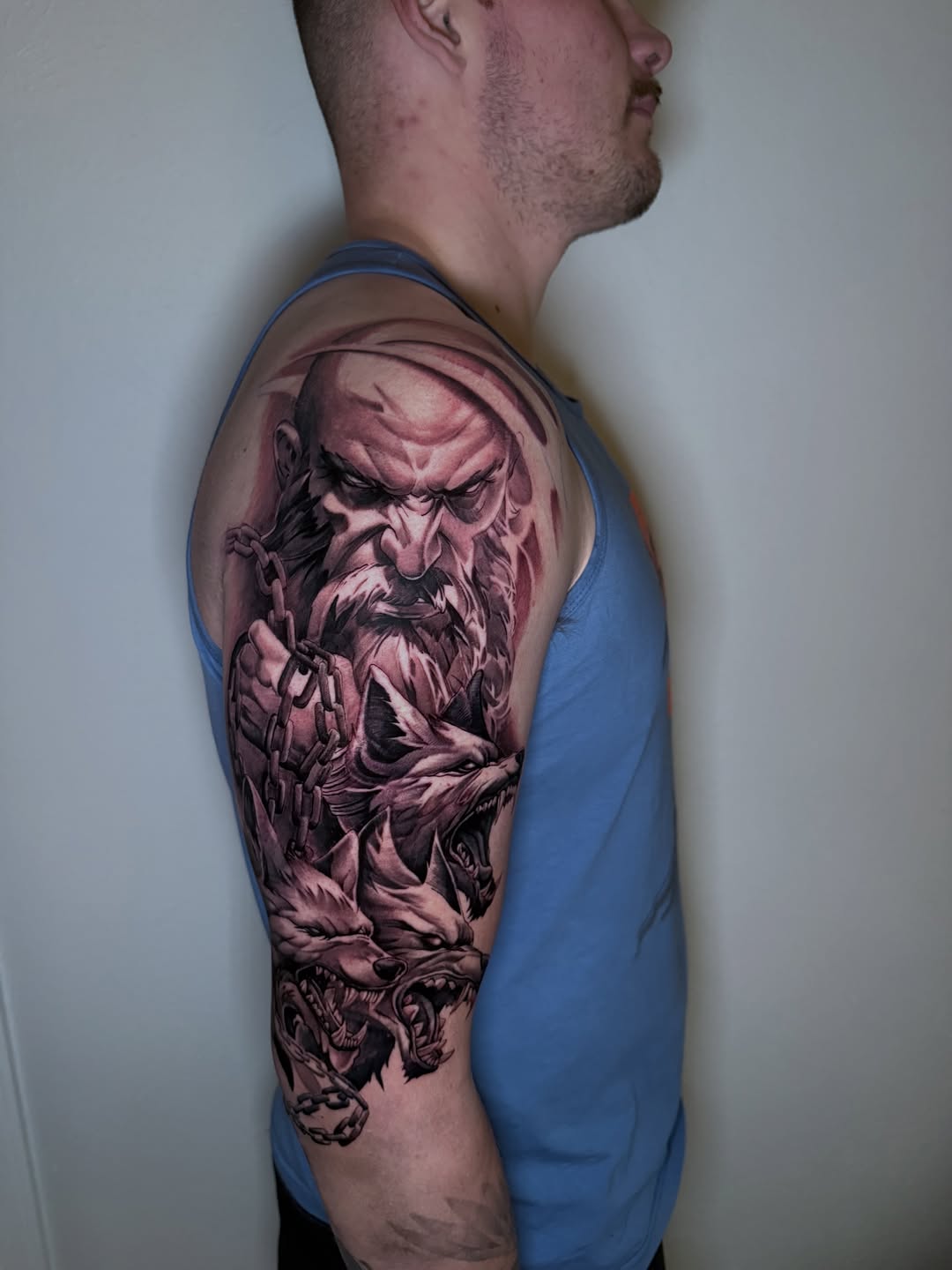 Man with wolves realism tattoo on the upper arm by Mike Nance
