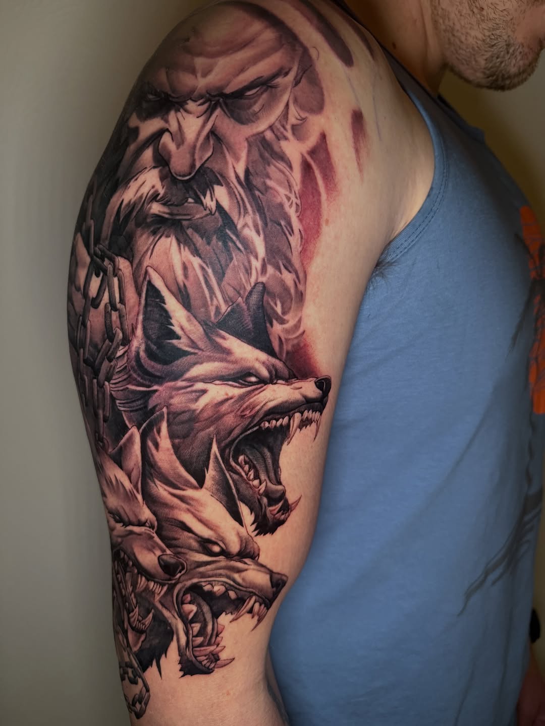 Three wolves and a bearded man realism tattoo on the upper arm by Mike Nance