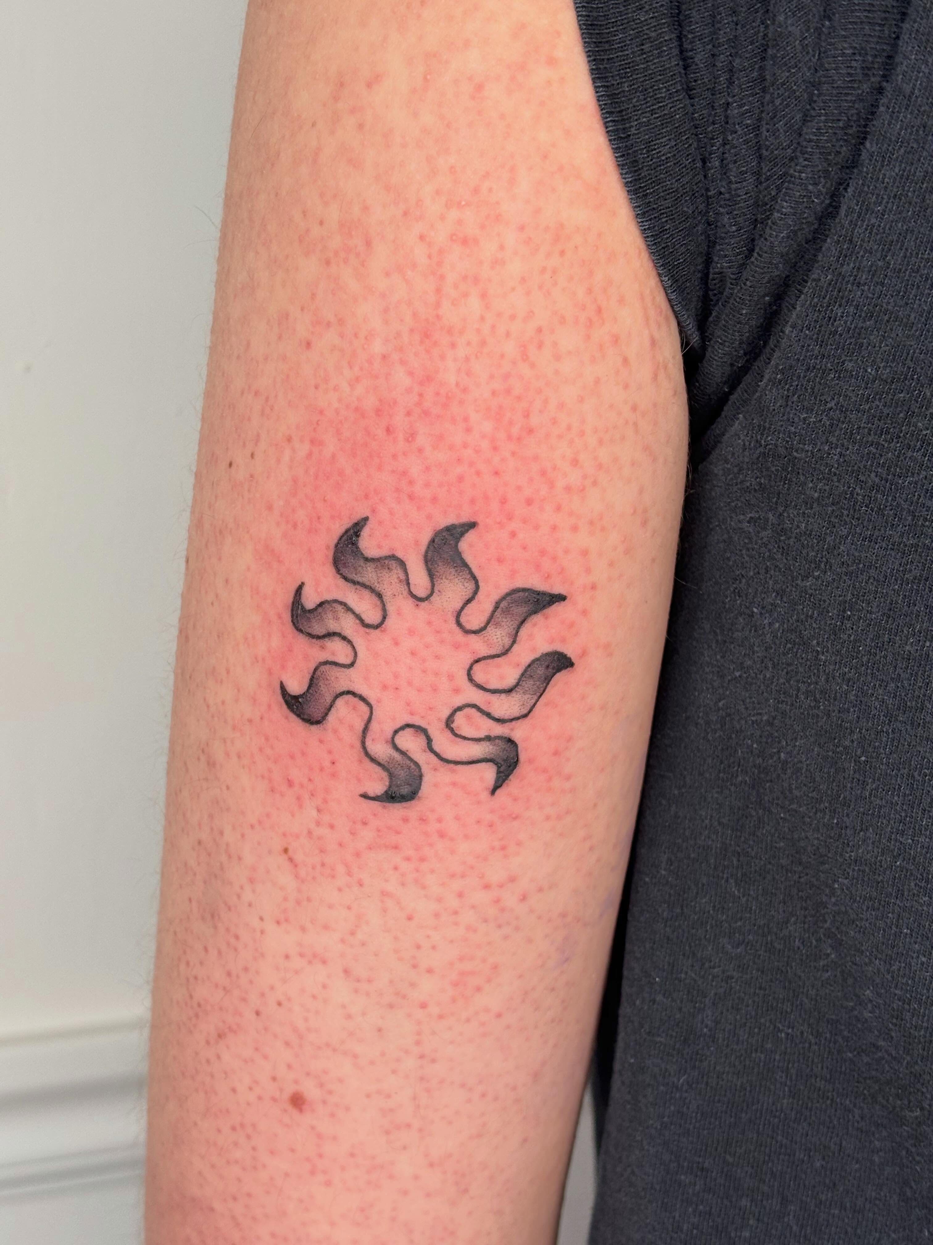 Flame black and grey tattoo on the forearm by Topher Belmont