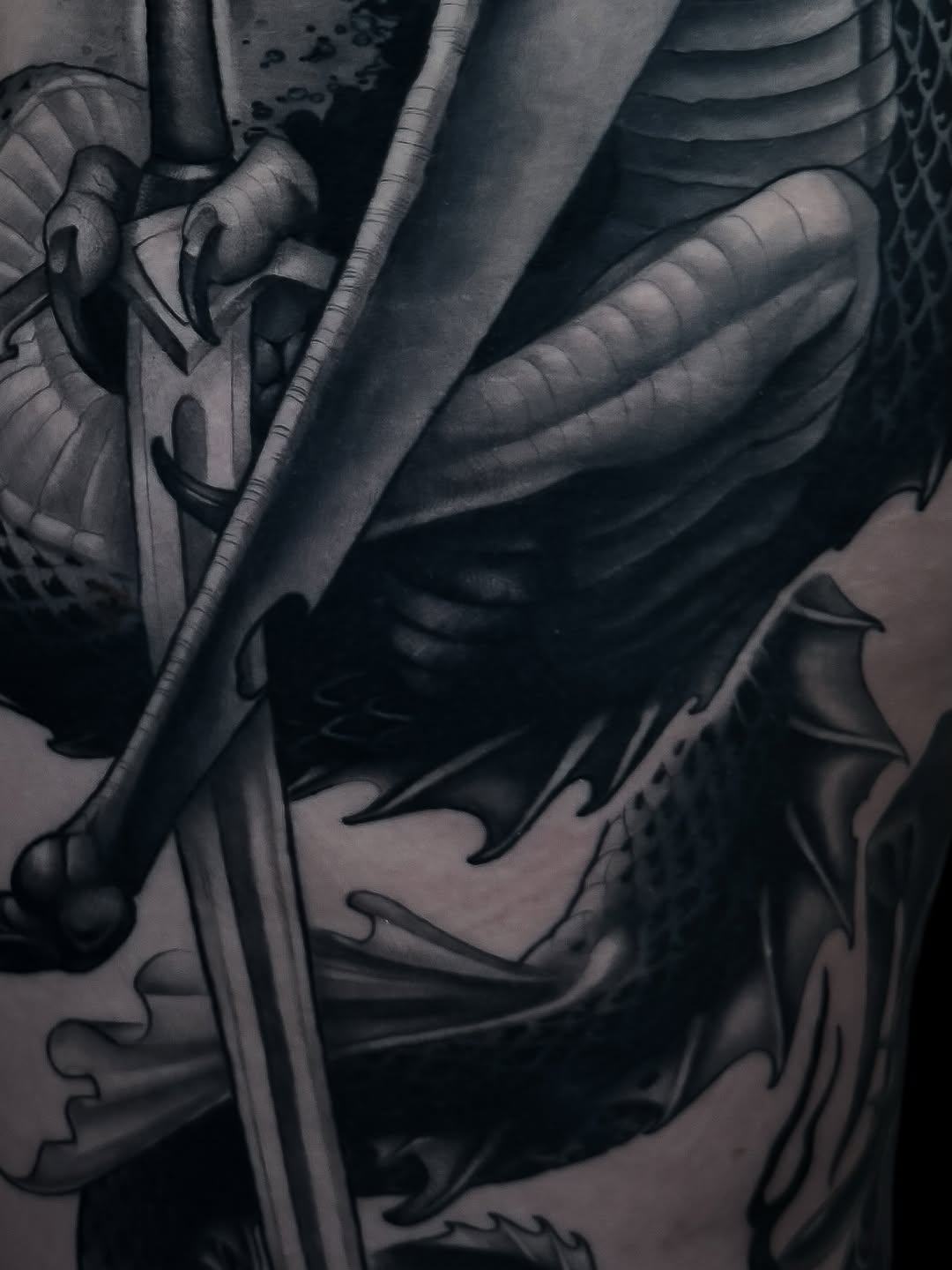 Dragon with sword realism tattoo on the torso by Carlos Valdes ✨ Tattoo Artist in Tampa FL
