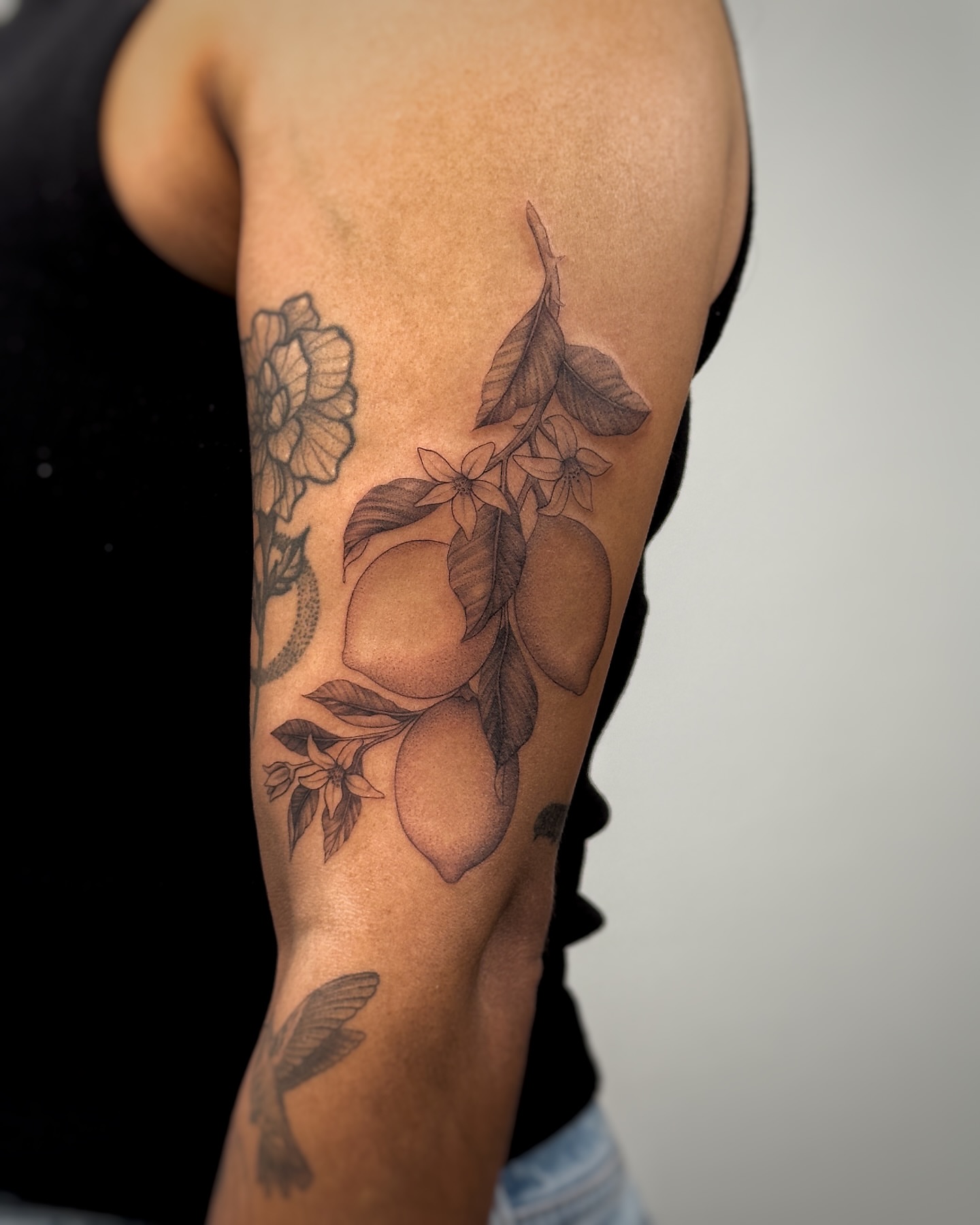 Fruit and floral arrangement realism tattoo on the forearm by Lea Burkard, Berkeley, California