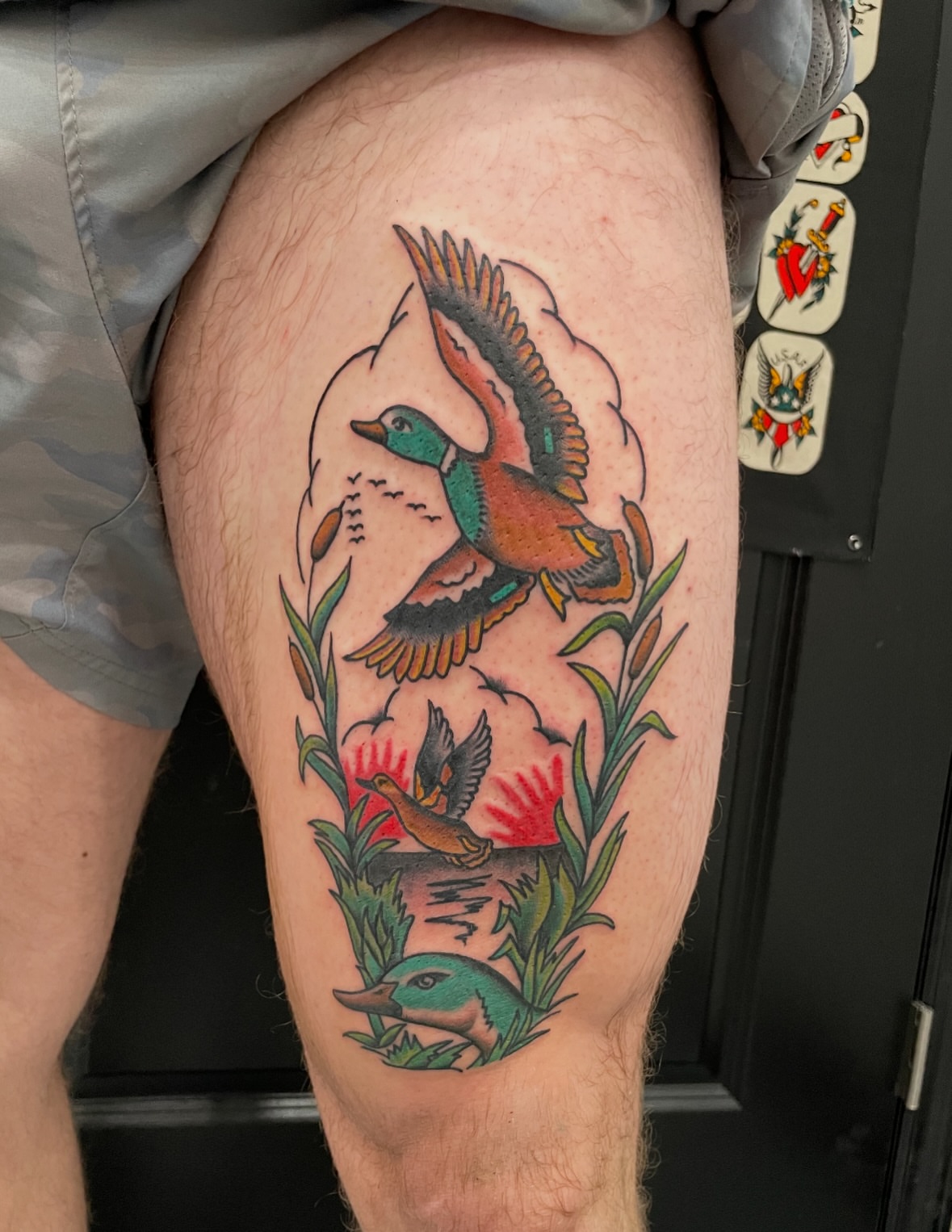 Ducks and flowers American traditional tattoo on the thigh by Greg De Hoot, Youngsville, North Carolina