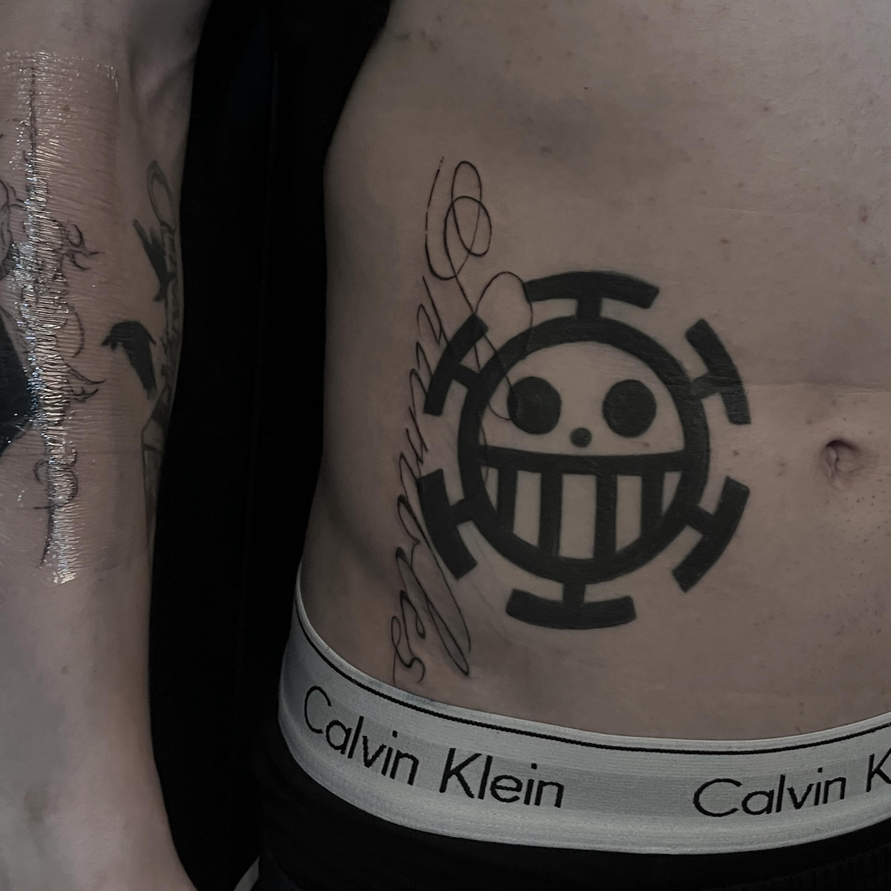 Smiling face with three horizontal lines black and grey tattoo on the ribs by kacper