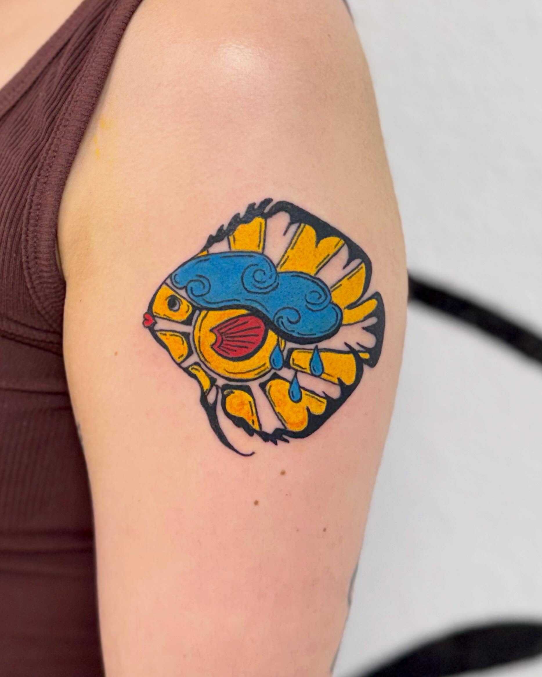 Fish new school tattoo on the upper arm by Peggy