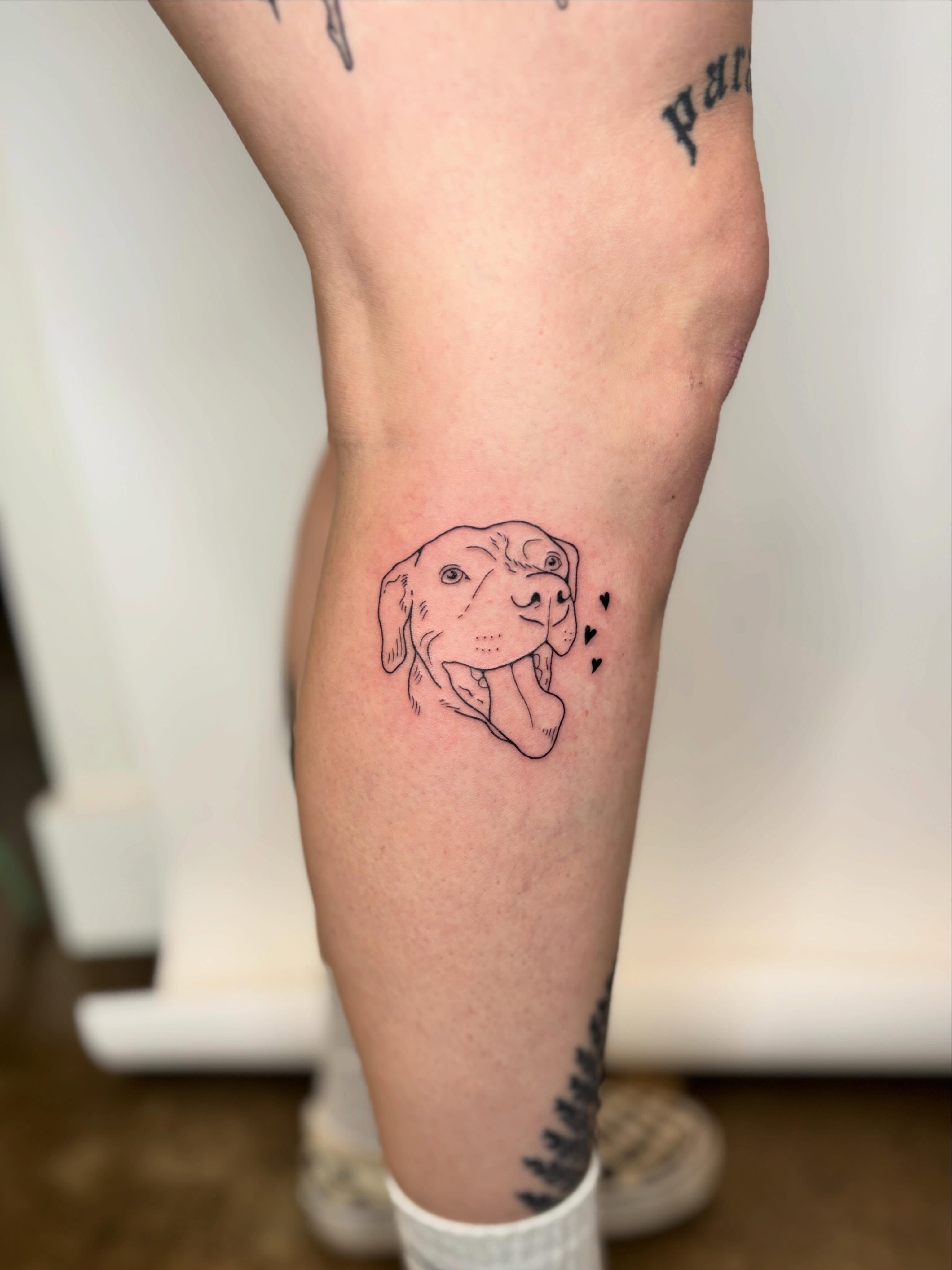 Dog fine line tattoo on the calf by Morgan