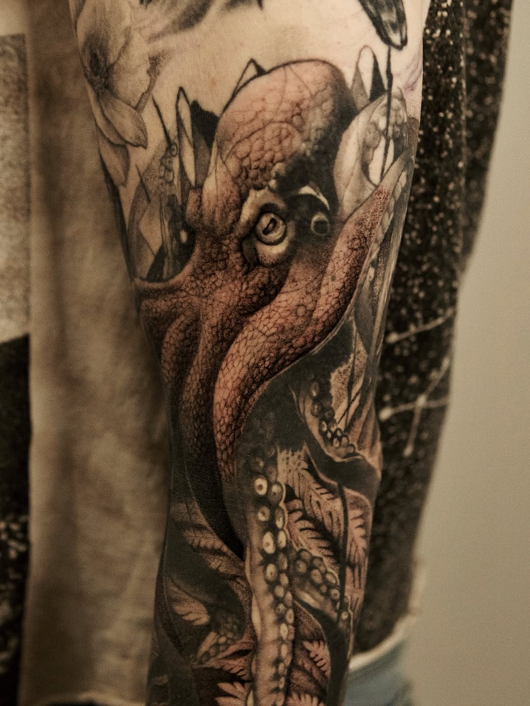Octopus and foliage realism tattoo on the forearm by Ray Quinday