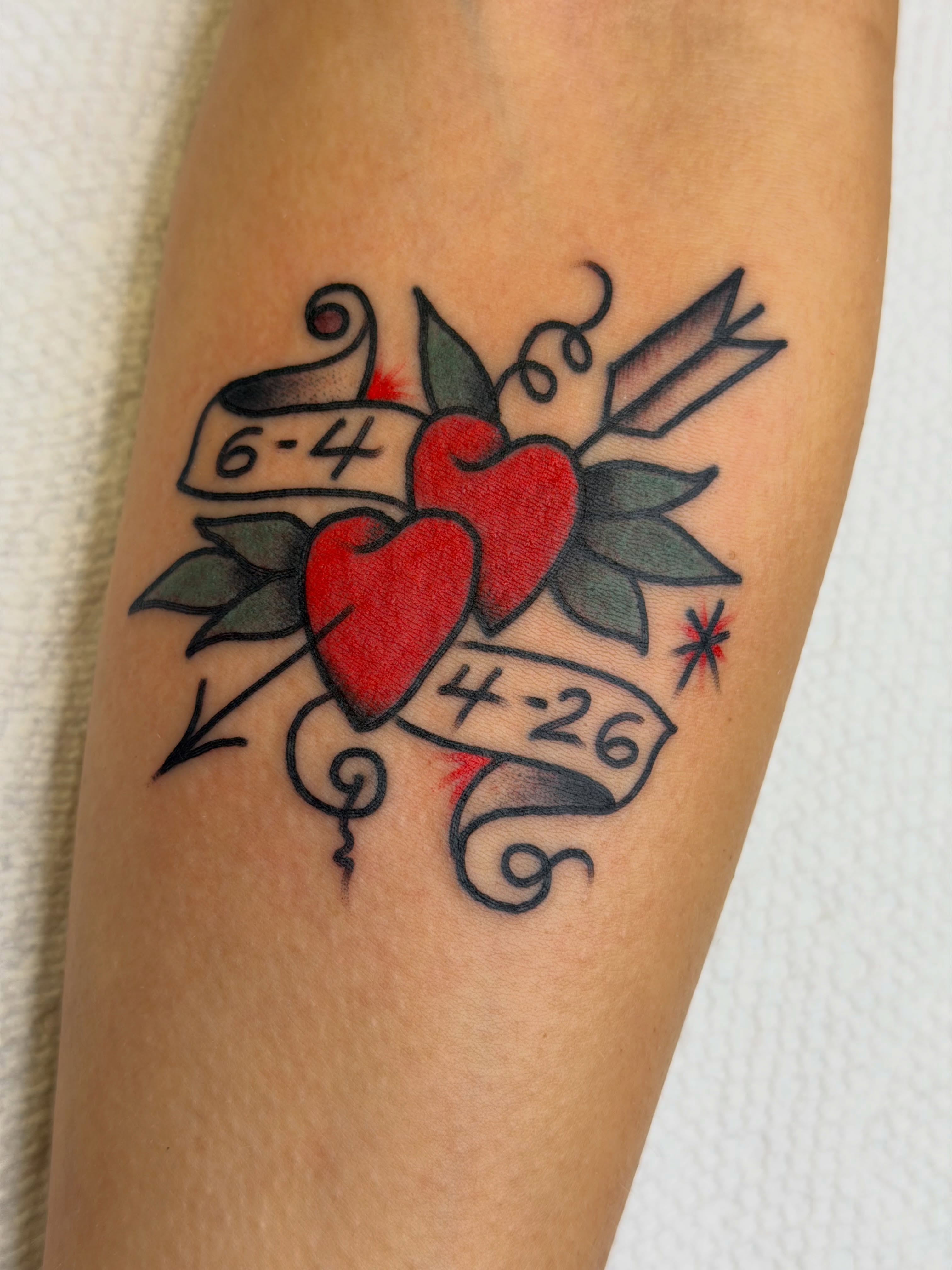 Two hearts with arrows American traditional tattoo on the forearm by morganhabe