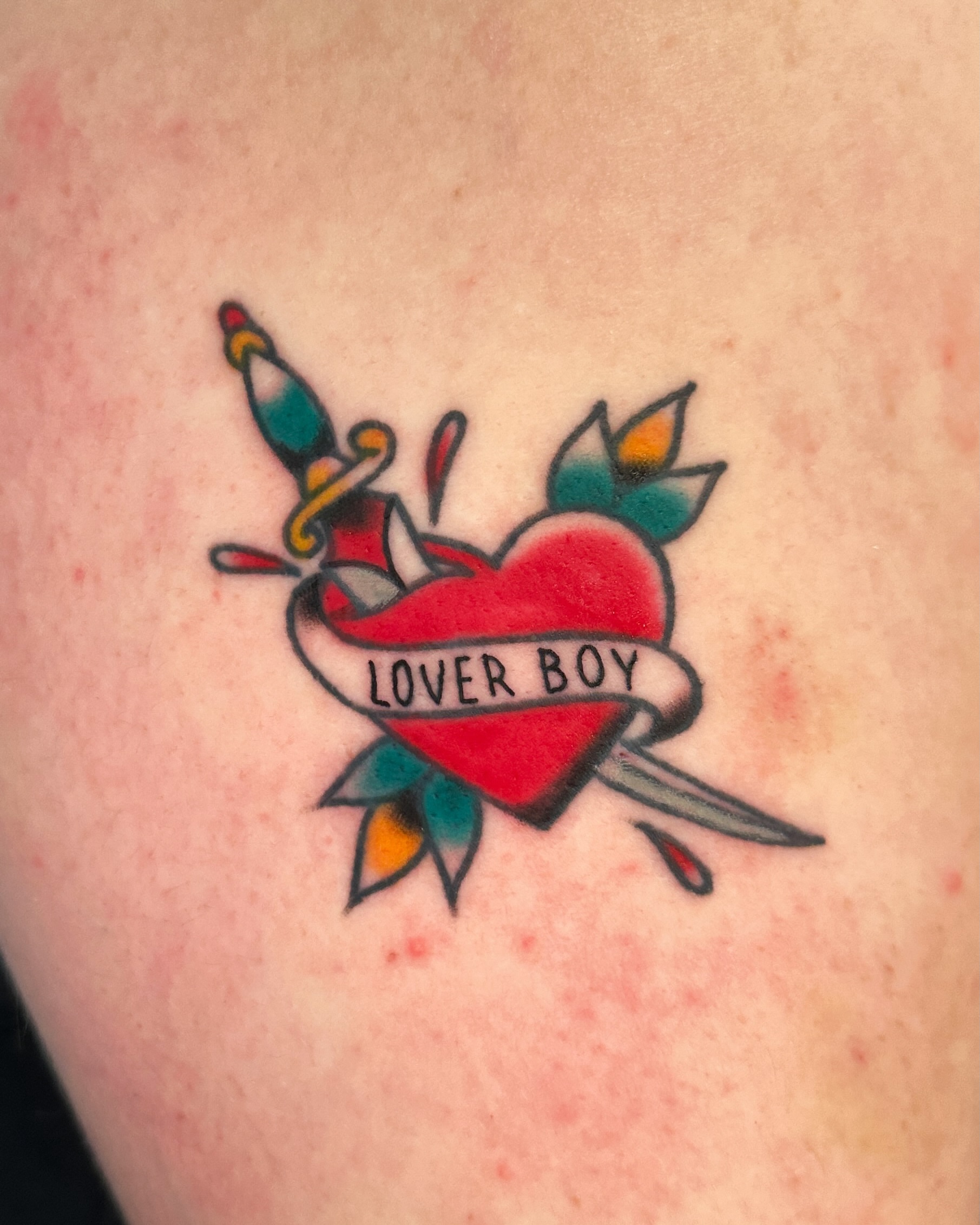 Heart with dagger American traditional tattoo on the shoulder by Paige Ochoa