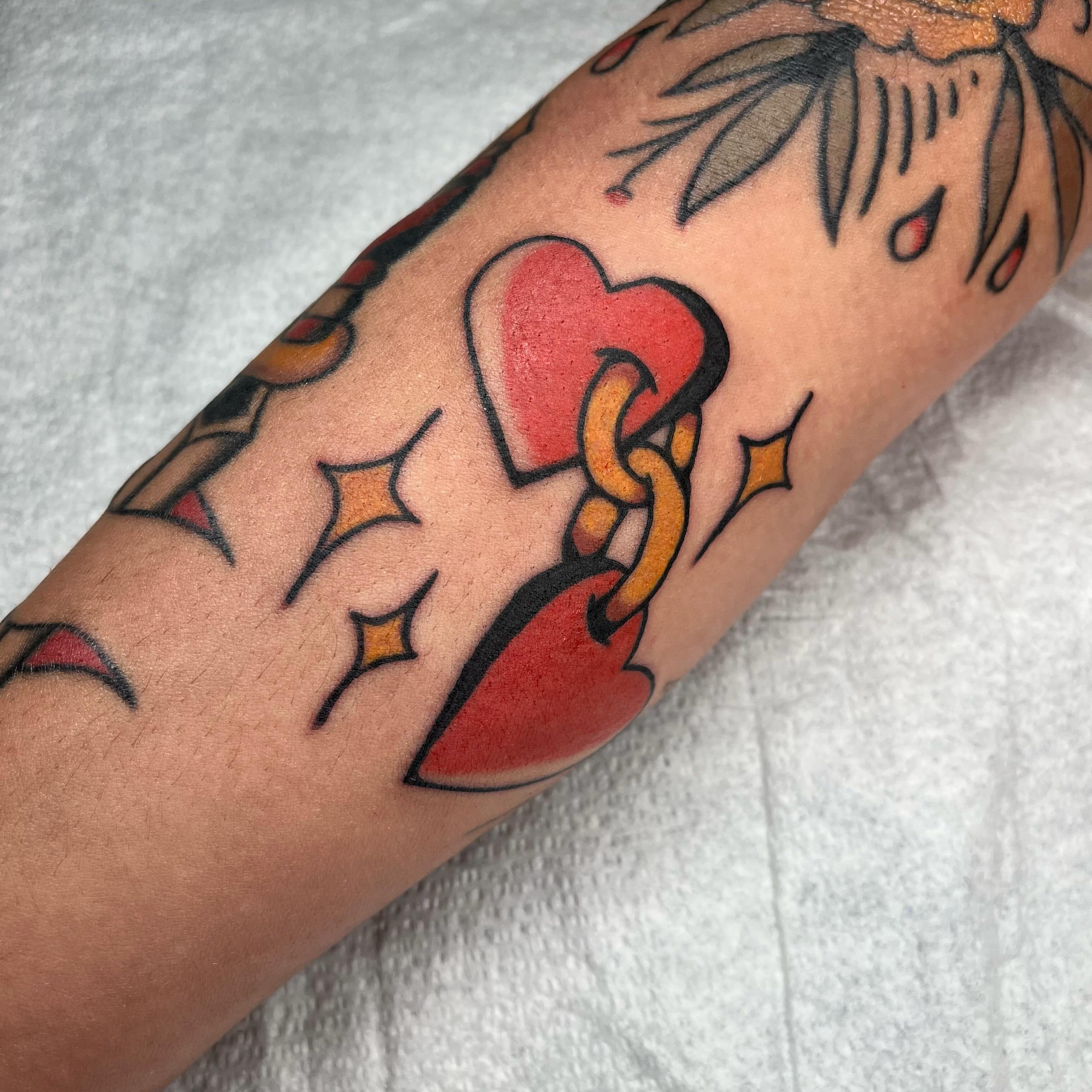 Heart and chain American traditional tattoo on the forearm by Jennifer Medrano