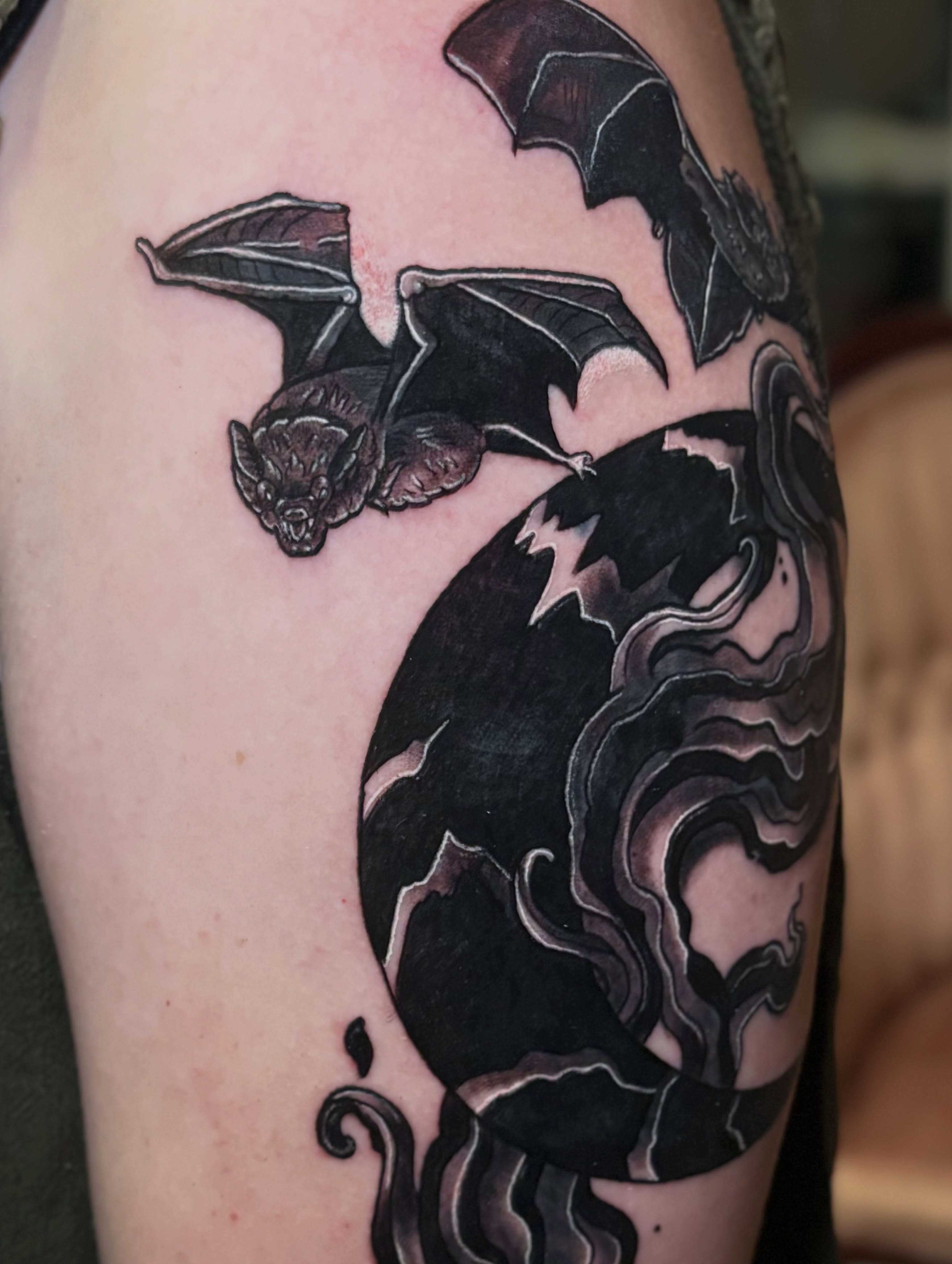 Bat and swirling smoke dark realism tattoo on the shoulder by Bekah Smith
