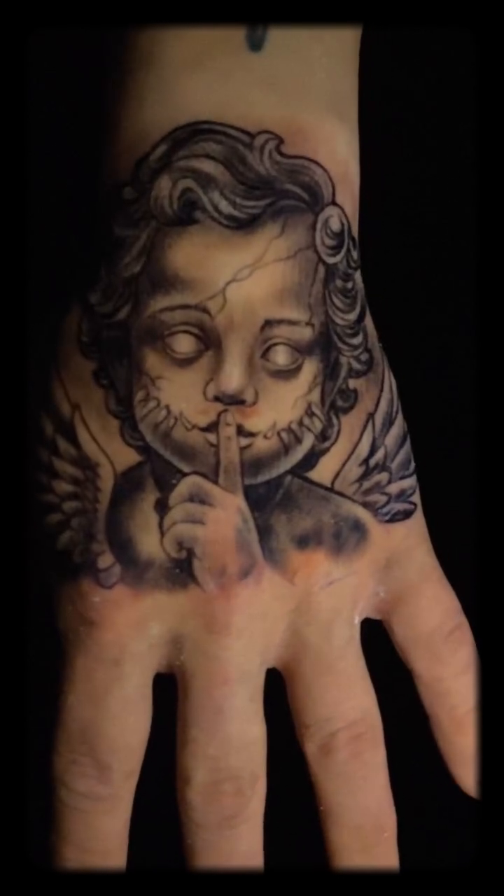 Cherub with finger to lips dark realism tattoo by Breyner, Cambridge, Massachusetts