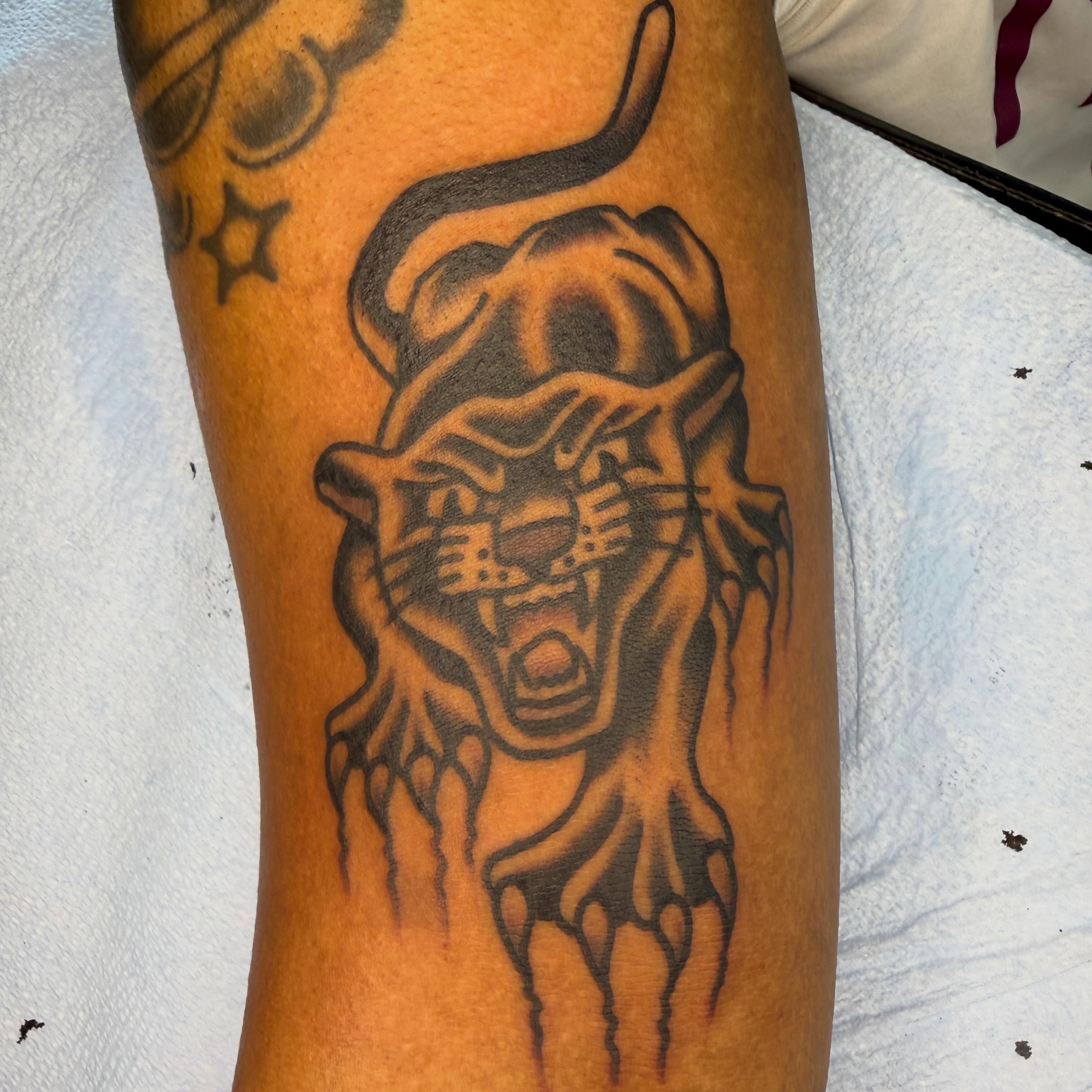 Roaring panther black and grey tattoo on the forearm by Tyler