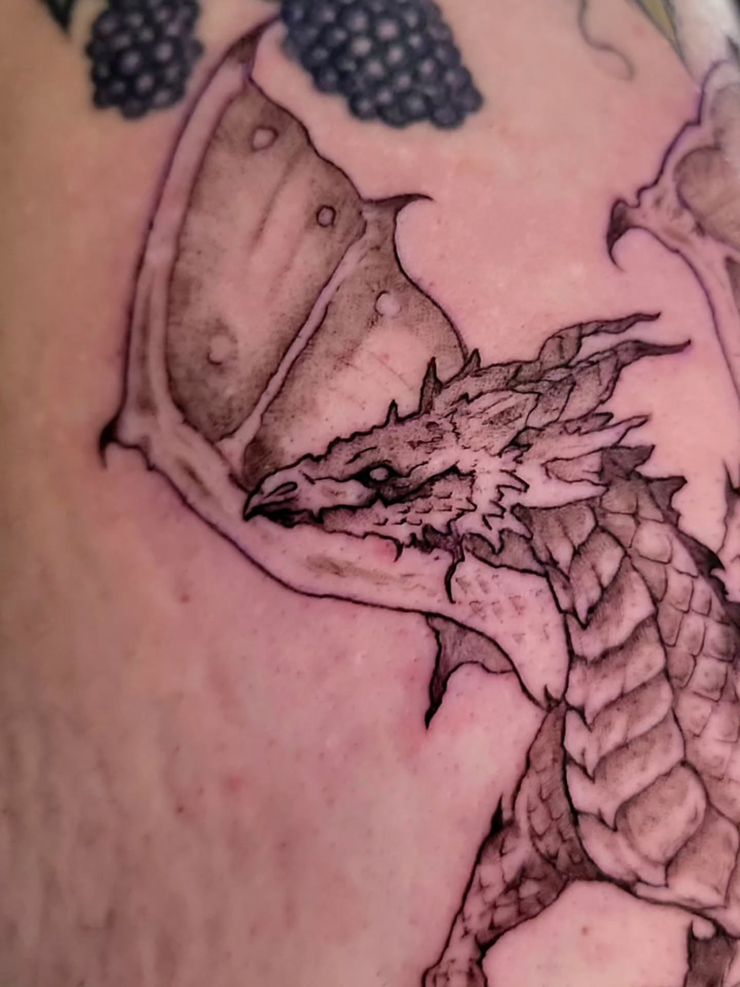 Dragon black and grey tattoo on the upper arm by Nathan Harkins-Oberbeck