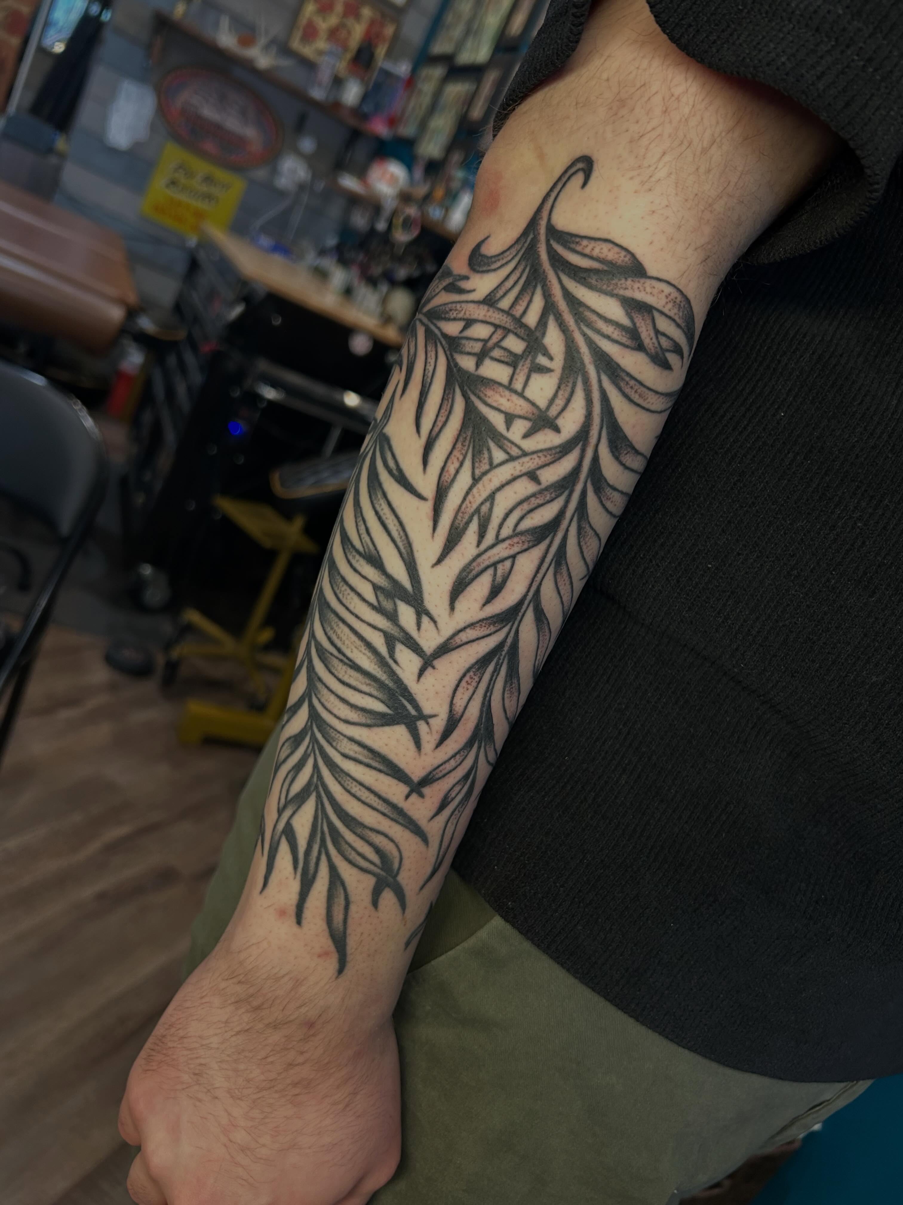 Feather black and grey tattoo on the forearm by Morgan Mansfield