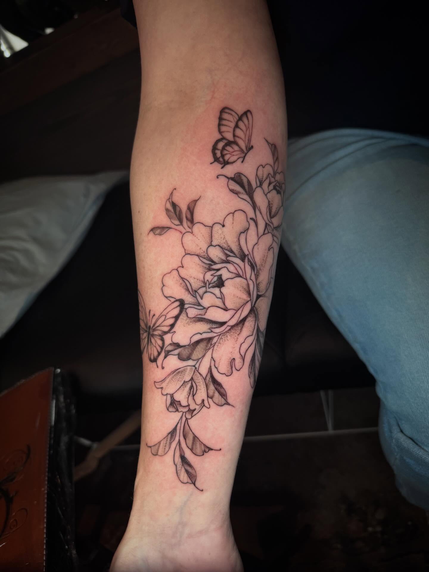 Peony and butterfly black and grey tattoo on the forearm by Gabrielle Mack
