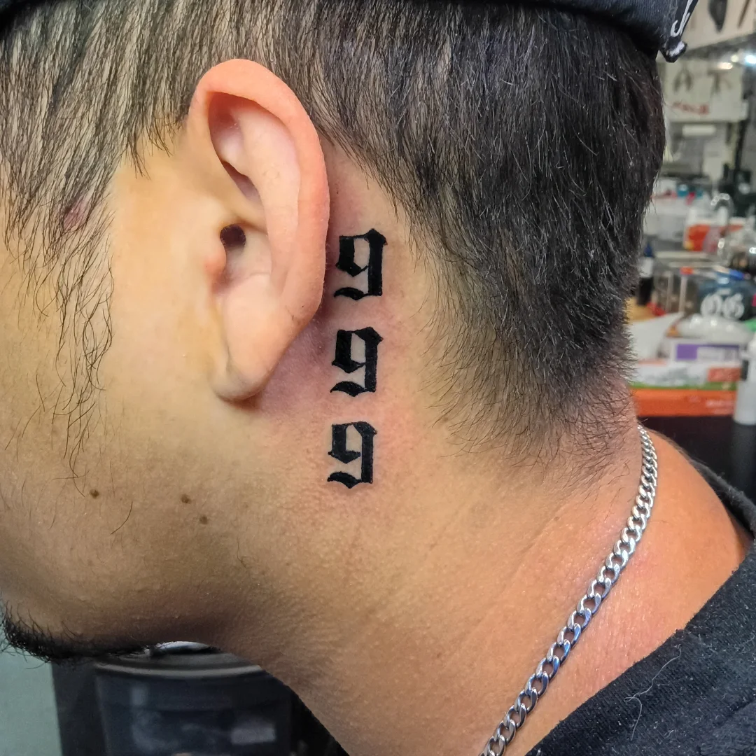 999 lettering script tattoo on the neck by Rando Rad