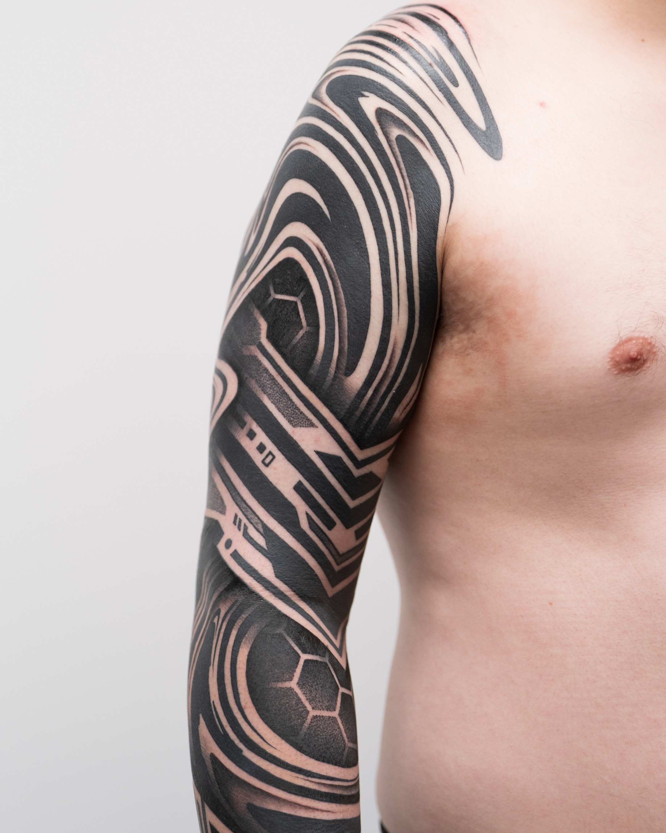 Geometric pattern geometric tattoo on the upper arm by Katie Mizuno, Berkeley, California