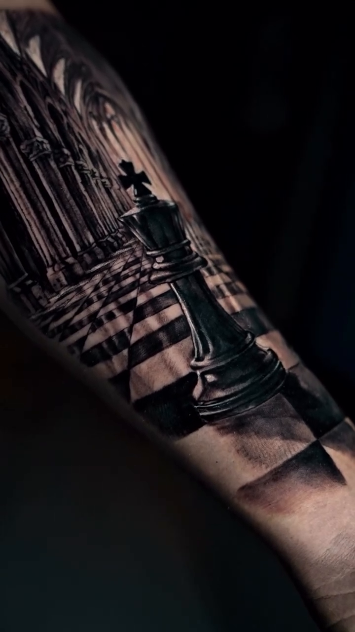 Chess pieces in a cathedral surrealism tattoo on the forearm by Alberto M