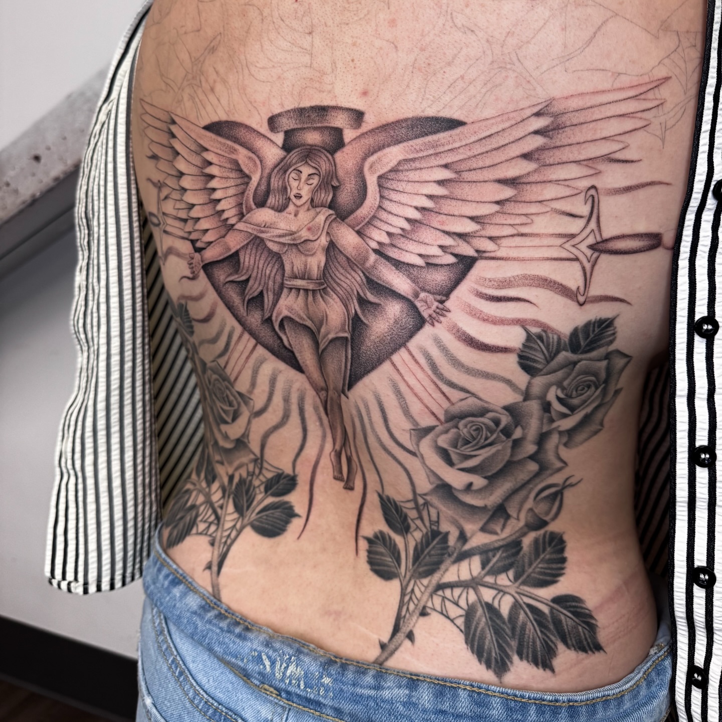 Angel with roses realism tattoo on the ribs by @nudylicioustattoos