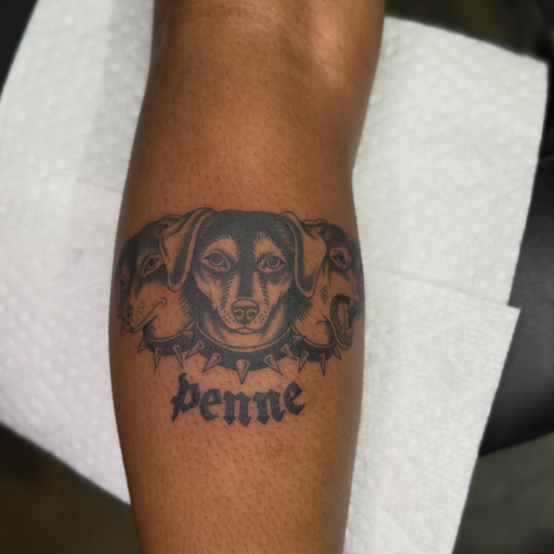 Dogs black and grey tattoo on the forearm by Allie Barringer