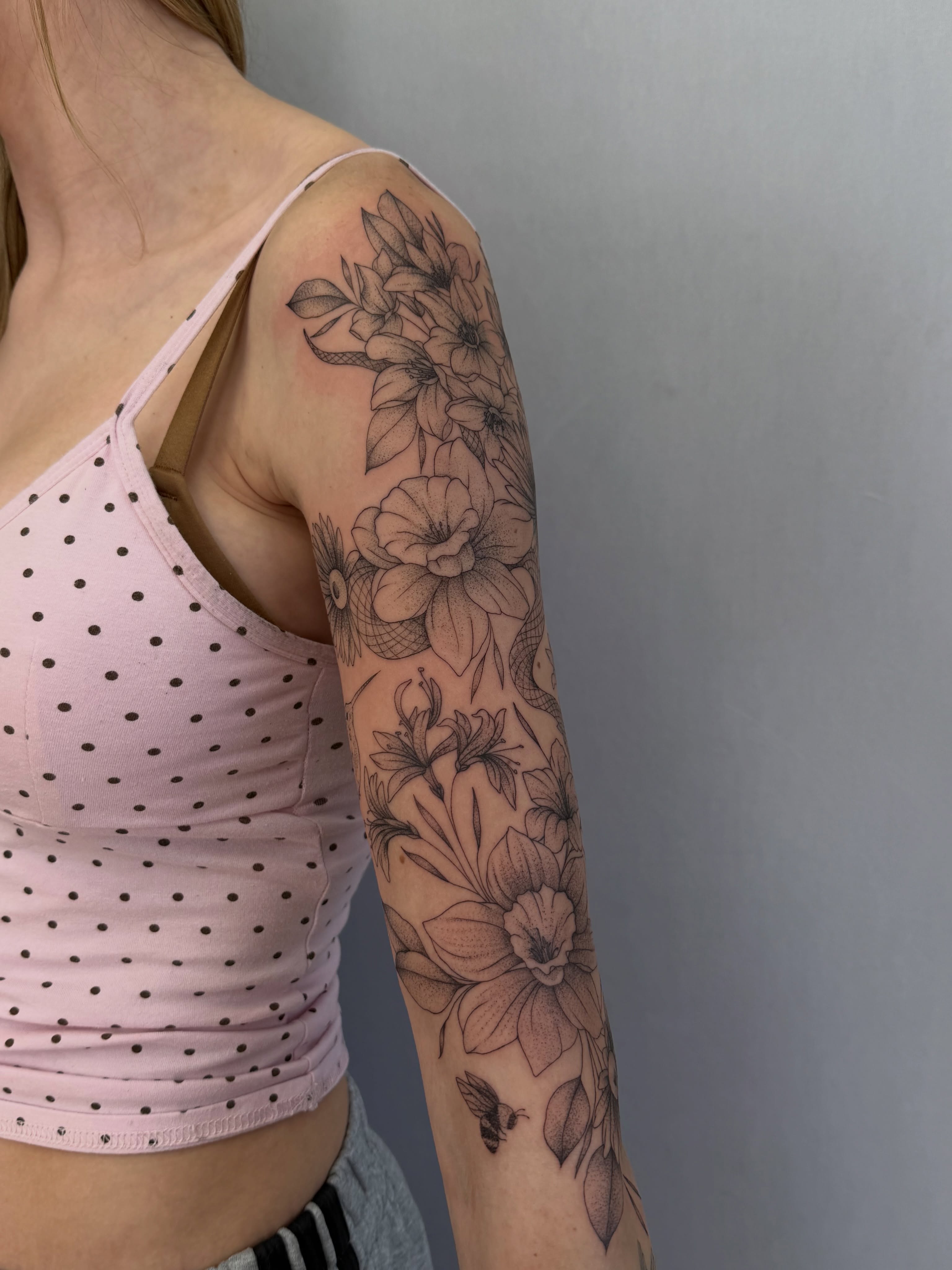 Floral arrangement black and grey tattoo on the upper arm by Henesee Parfitt