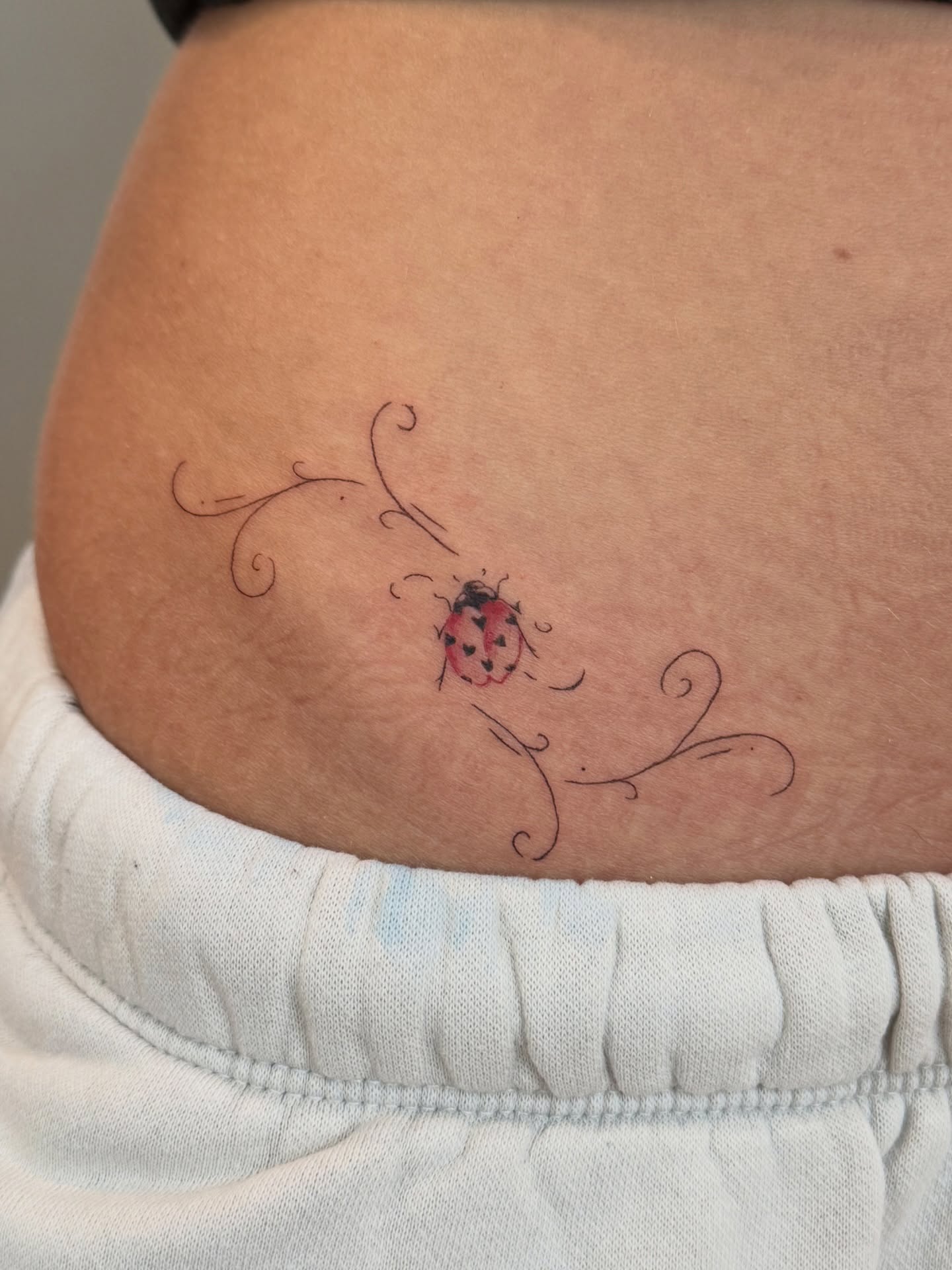 Ladybug dotwork tattoo on the thigh by Fine Line Tattoos