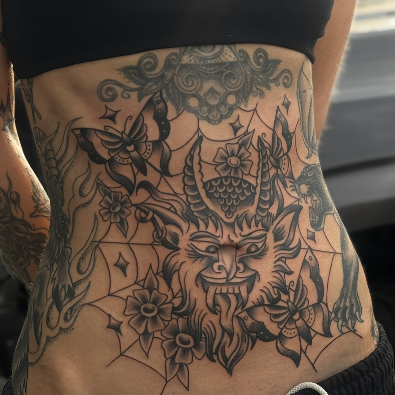 Demon face with flowers American traditional tattoo on the torso by ๐ช๐๐ก๐ก๐ฆ๐ข