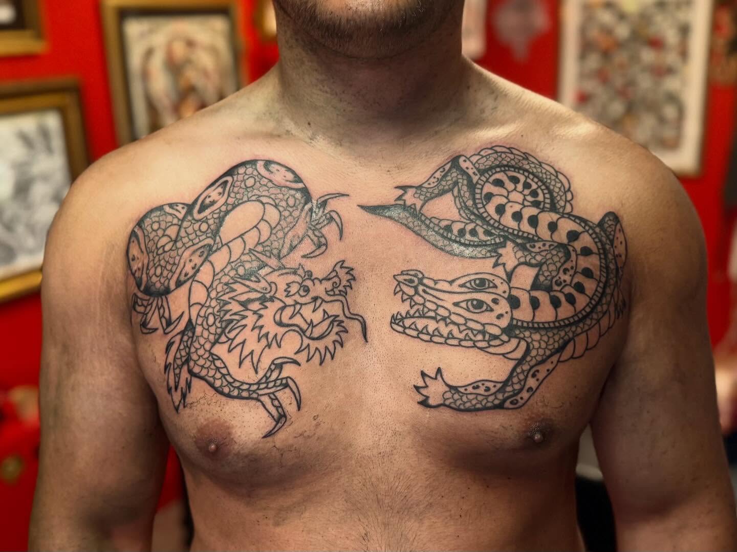 Dragon and snake black and grey tattoo on the chest by Jacqui Rose