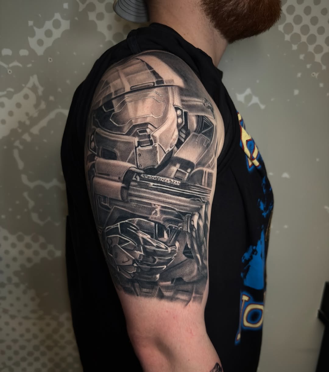 Master Chief helmet and weapon realism tattoo on the upper arm by Charlotte Tattoo Artist
