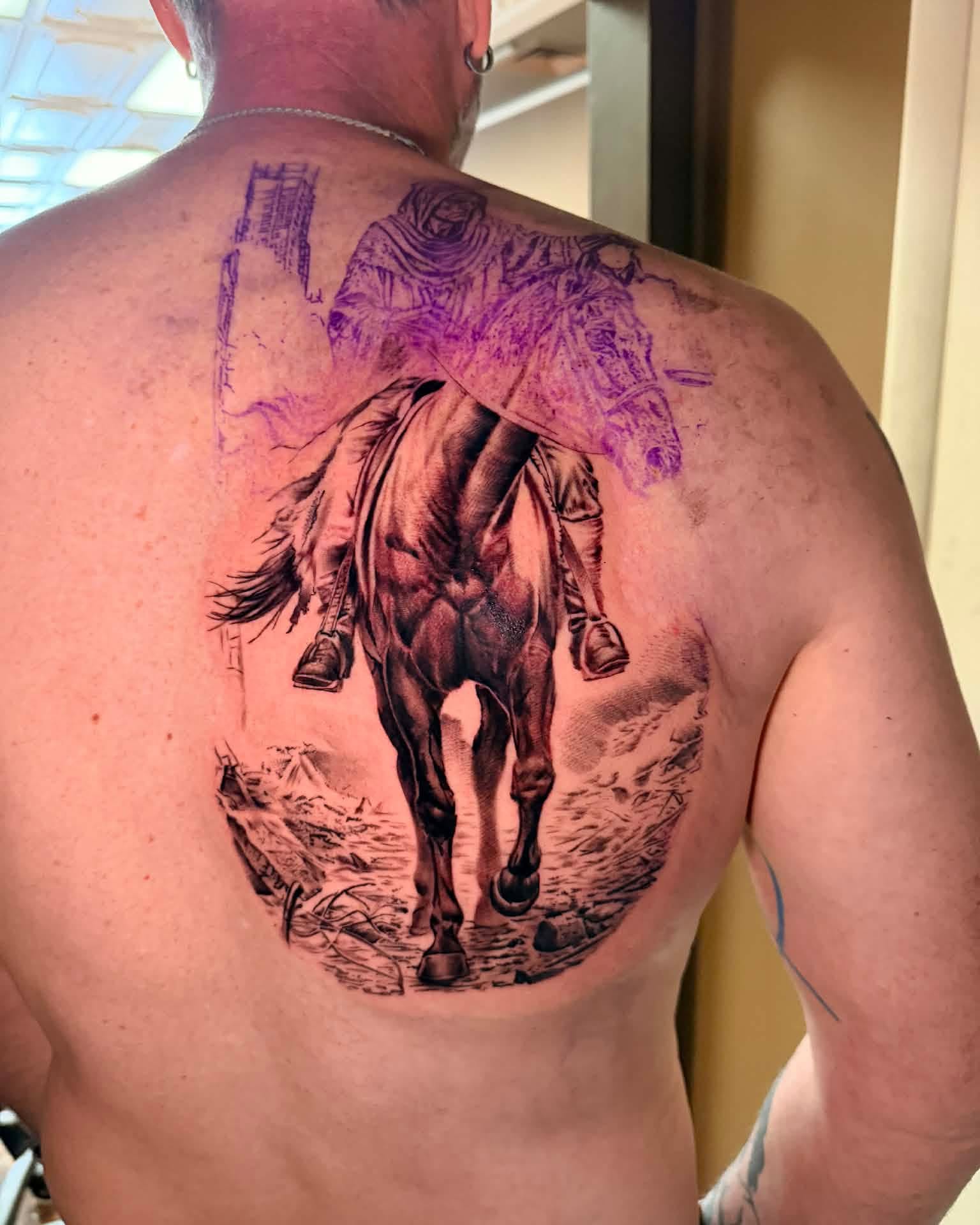 Horse and rider realism tattoo on the back by Zacharee Osborn