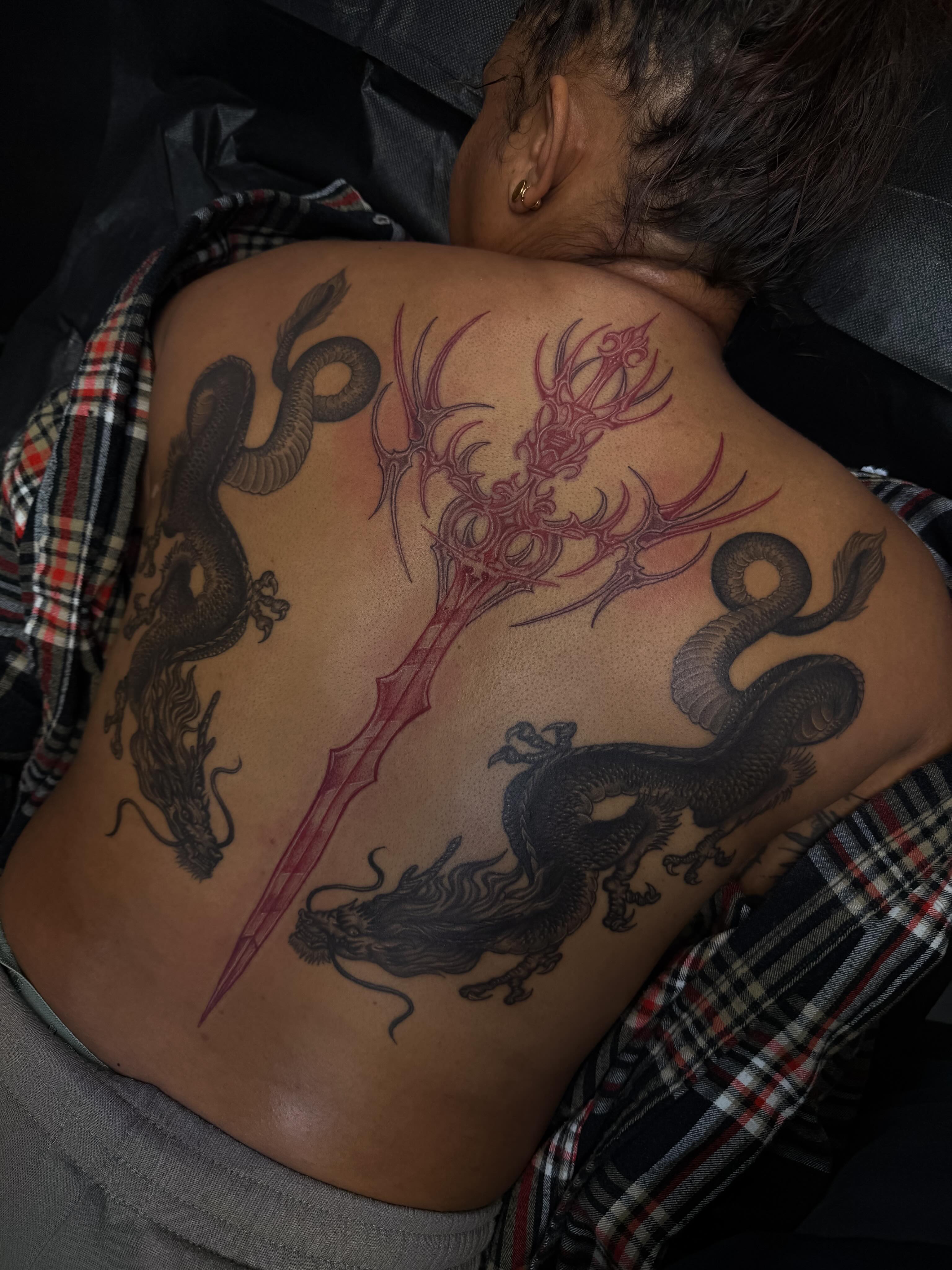 Dragon and spear geometric tattoo on the back by Yvonne