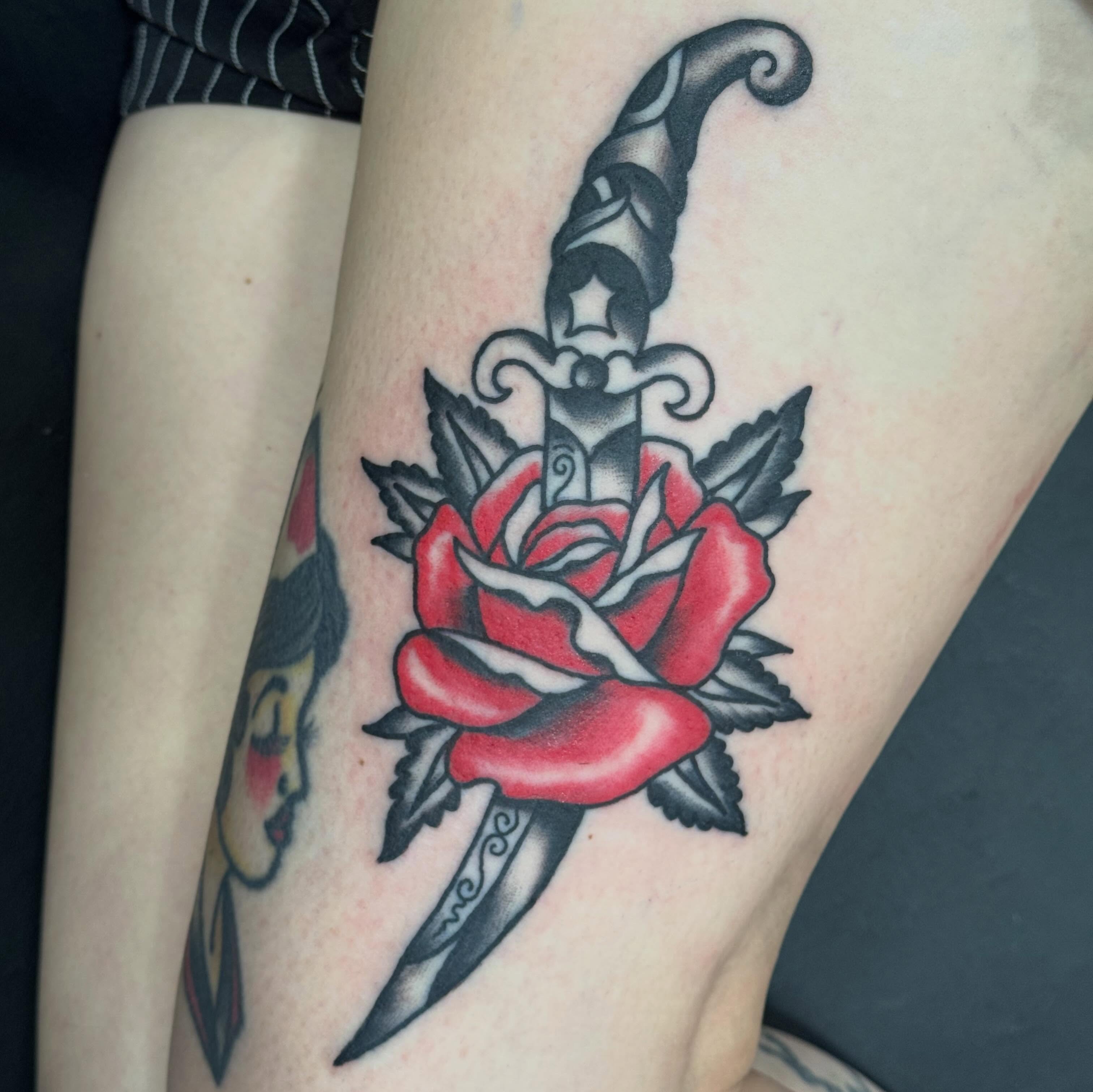 Knife and rose American traditional tattoo on the thigh by Jack Hatchet Tattoos
