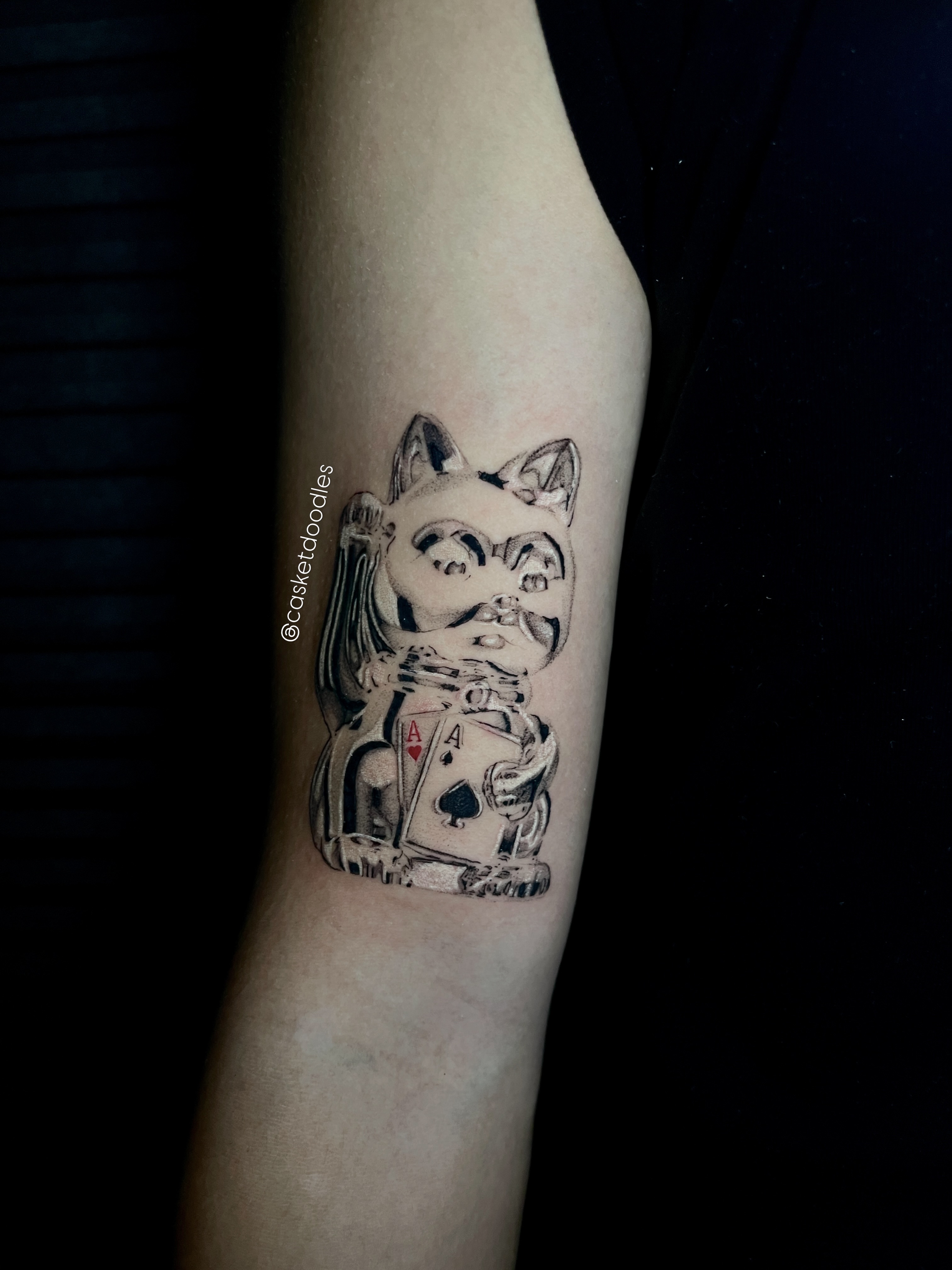Cat with playing cards black and grey tattoo on the forearm by clarissa