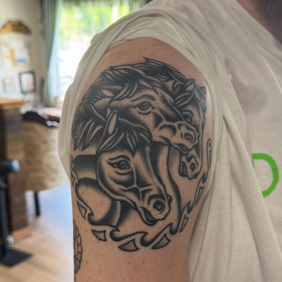 Horse heads black and grey tattoo on the shoulder by Larry Love